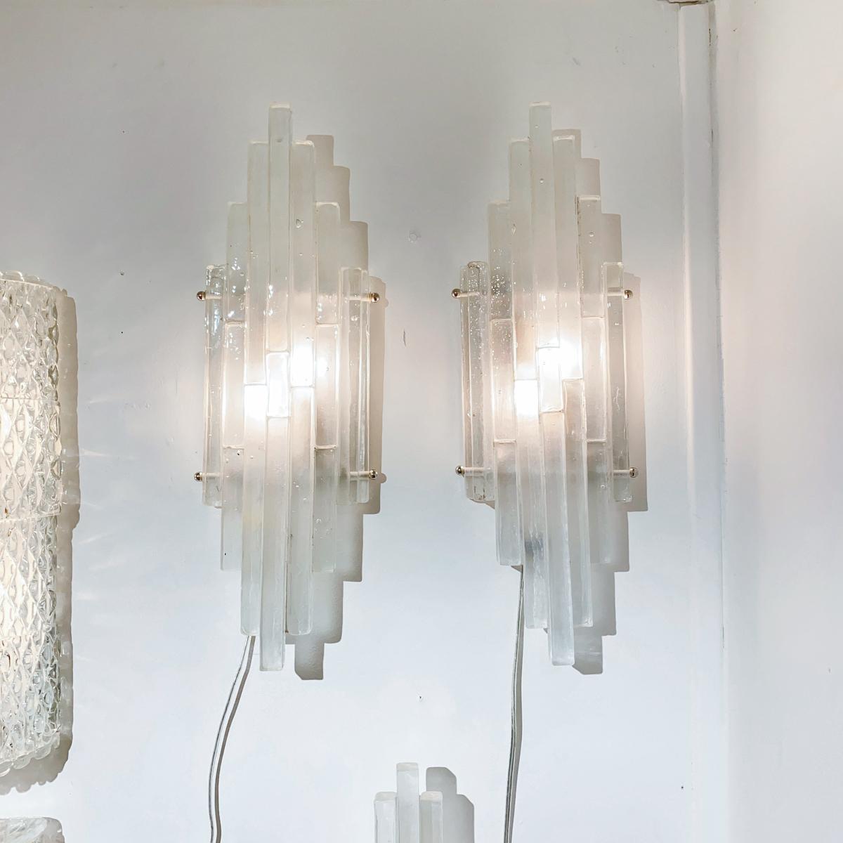 Sconces composed of clustered frosted glass strips in a graduated arrangement by Poliarte.