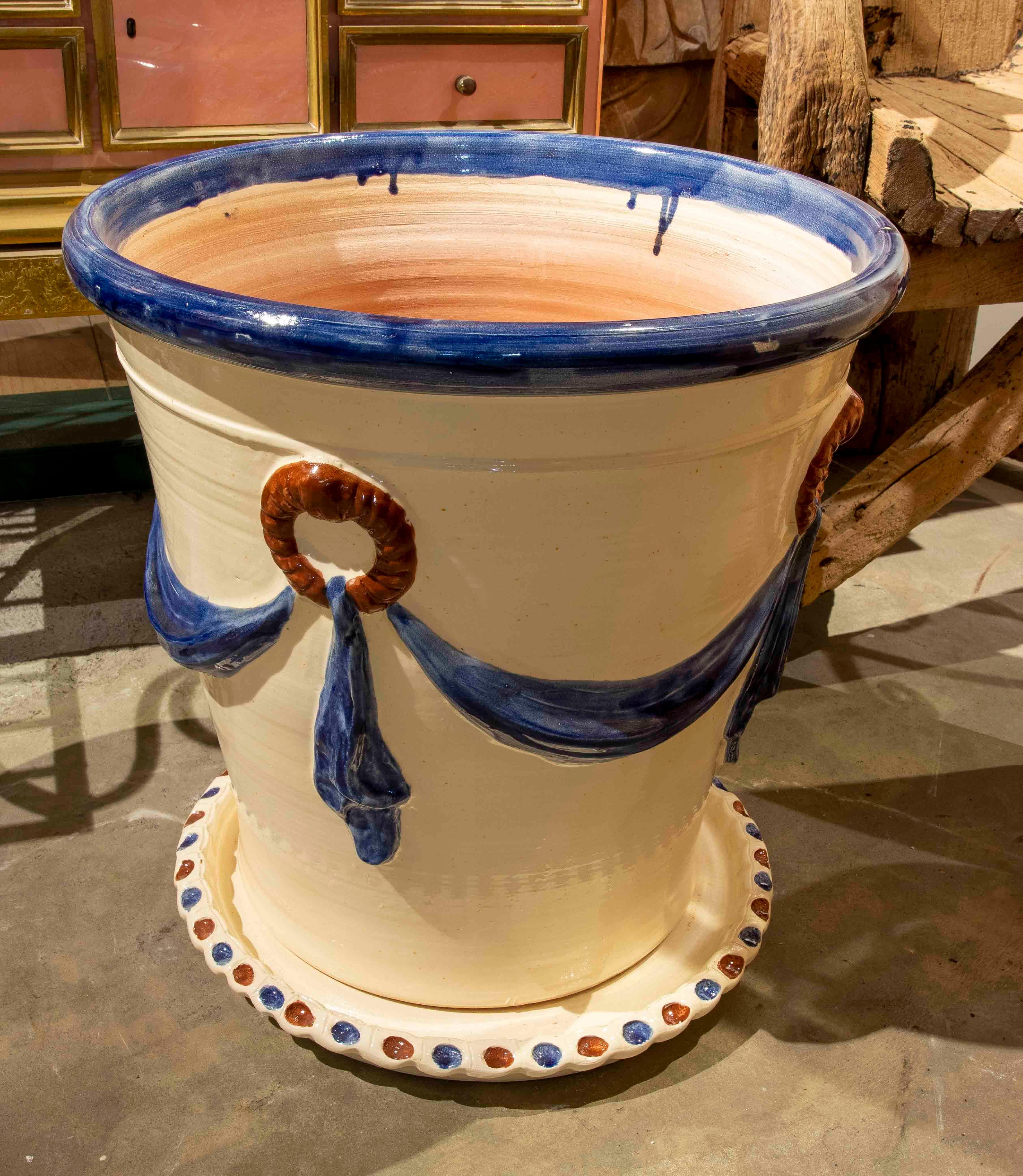 Paire de pots de fleurs en céramique émaillée de couleur bleu et blanc cassé avec soucoupes