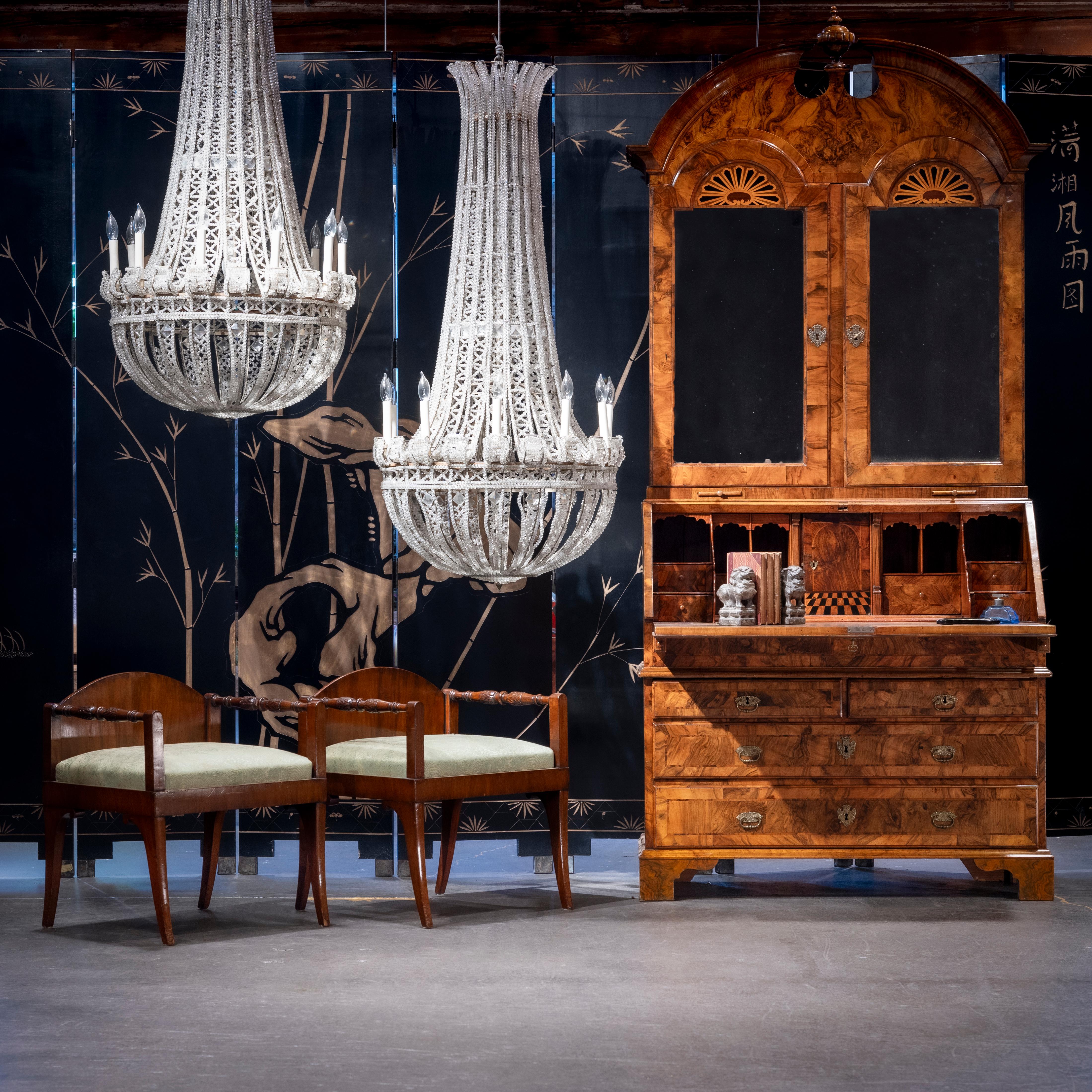 These spectacular tent-and-bag chandeliers from the early 20th century are beautifully strung from top to bottom with sparkling crystal beads over a plated metal body. The monumental chandeliers are designed in the Empire style with round basket