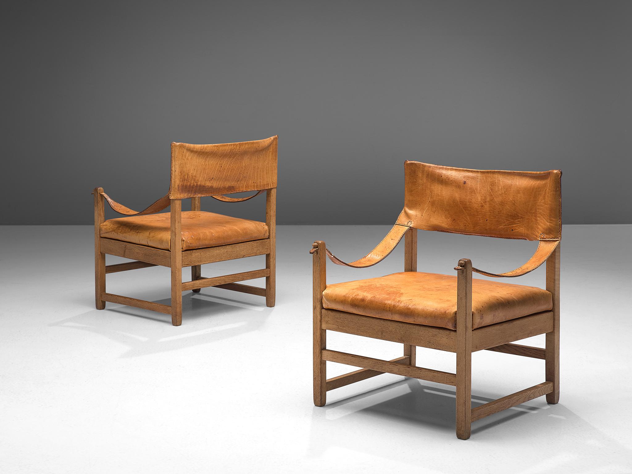 Grand lounge chairs, oak and cognac leather, France, 1960s.

This set of two lounge chairs is designed in France, made in solid oak and upholstered with cognac saddle leather. This set has a wonderful rich patina that makes this set extraordinary