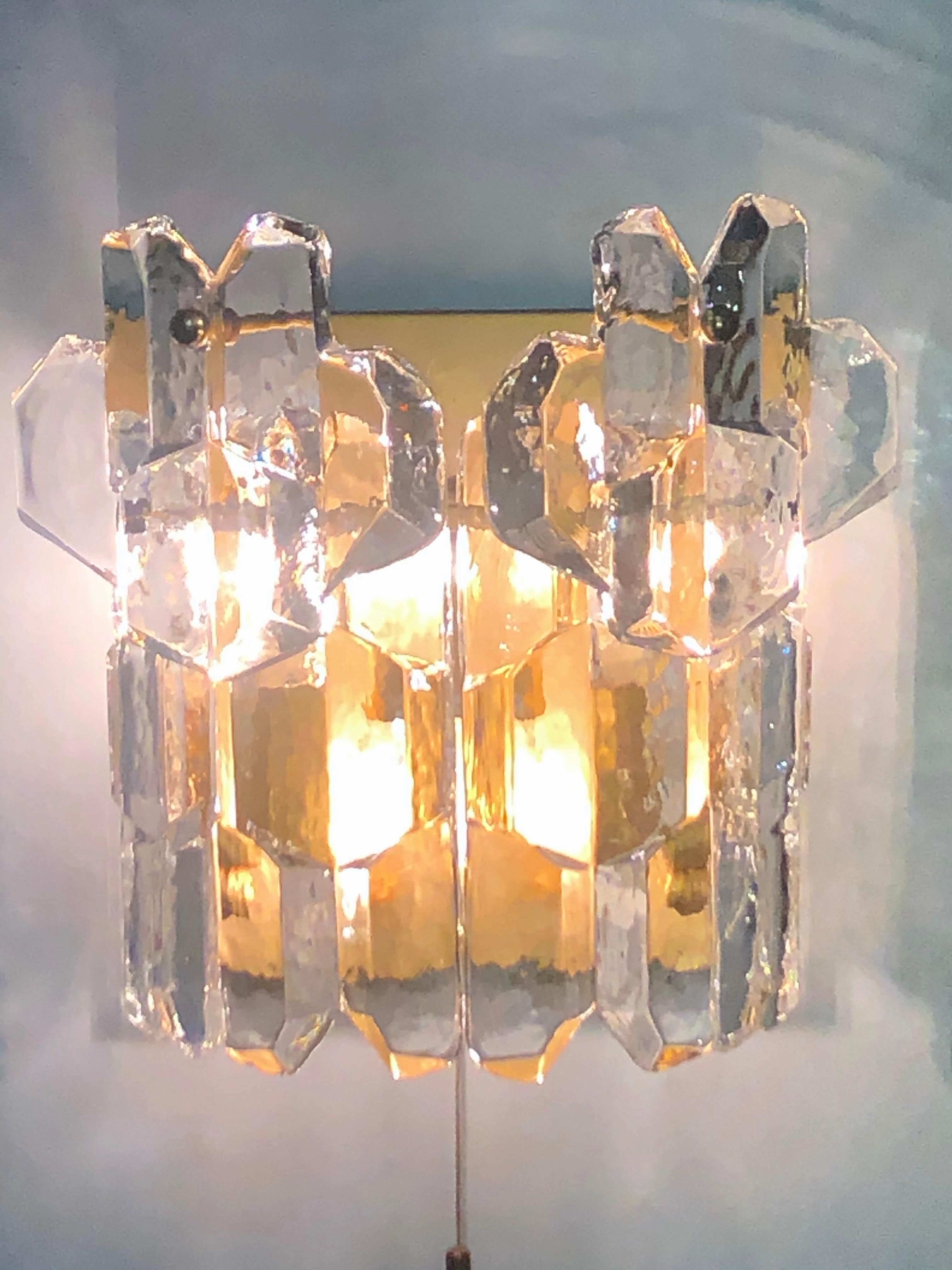 Beautiful pair of wall sconces by J.T. Kalmar, Austria, Vienna, 1960s.
The fixtures are made of each six heavy ice Murano glass elements hanging on a gilt brass frame.

Socket: Each 3 x e14 (for standard screw bulbs).
  