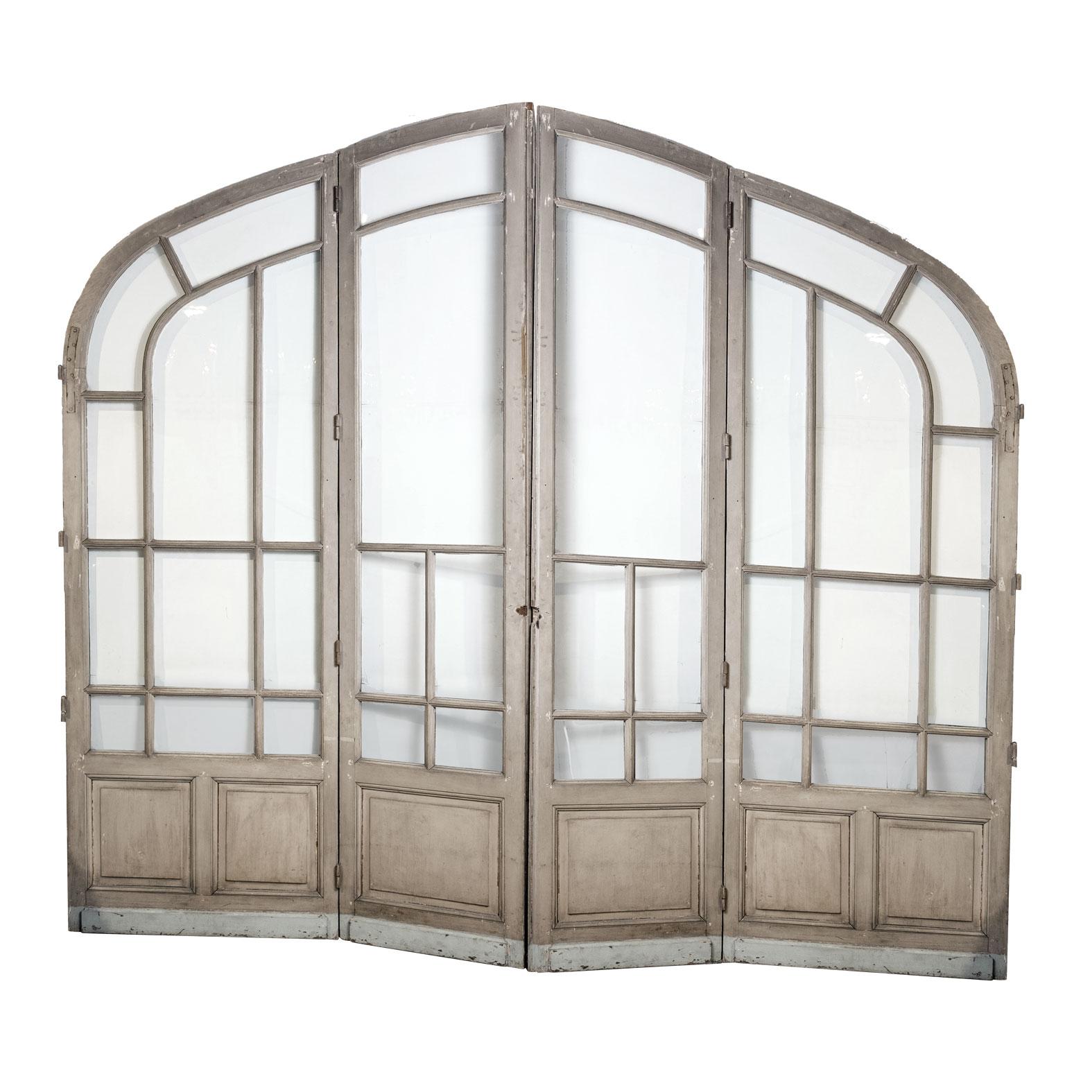 Pair of grand-scale arched glass paneled double doors. Contains (mostly) original glass plates (one missing, the second broken) Constructed, circa 1910 in Paris.

Note: Original/early finish on antique and vintage metal will include some, or all, of