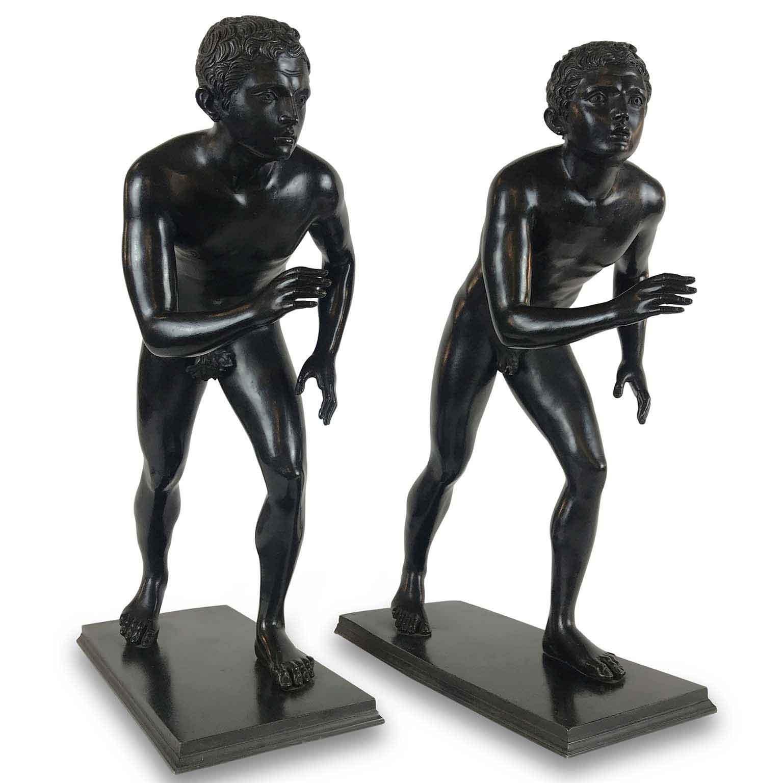 A Pair of Italian Grand Tour cast bronze sculptures of the Herculaneum runners, modeled after the antique models in the Villa of the Papyri, Herculaneum, now located in Neaples Royal Museum. 
Standing on a rectangular base, the two figures are in