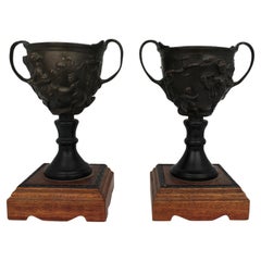 Coppia di urne a due manici in bronzo del Grand Tour su basi in legno successive