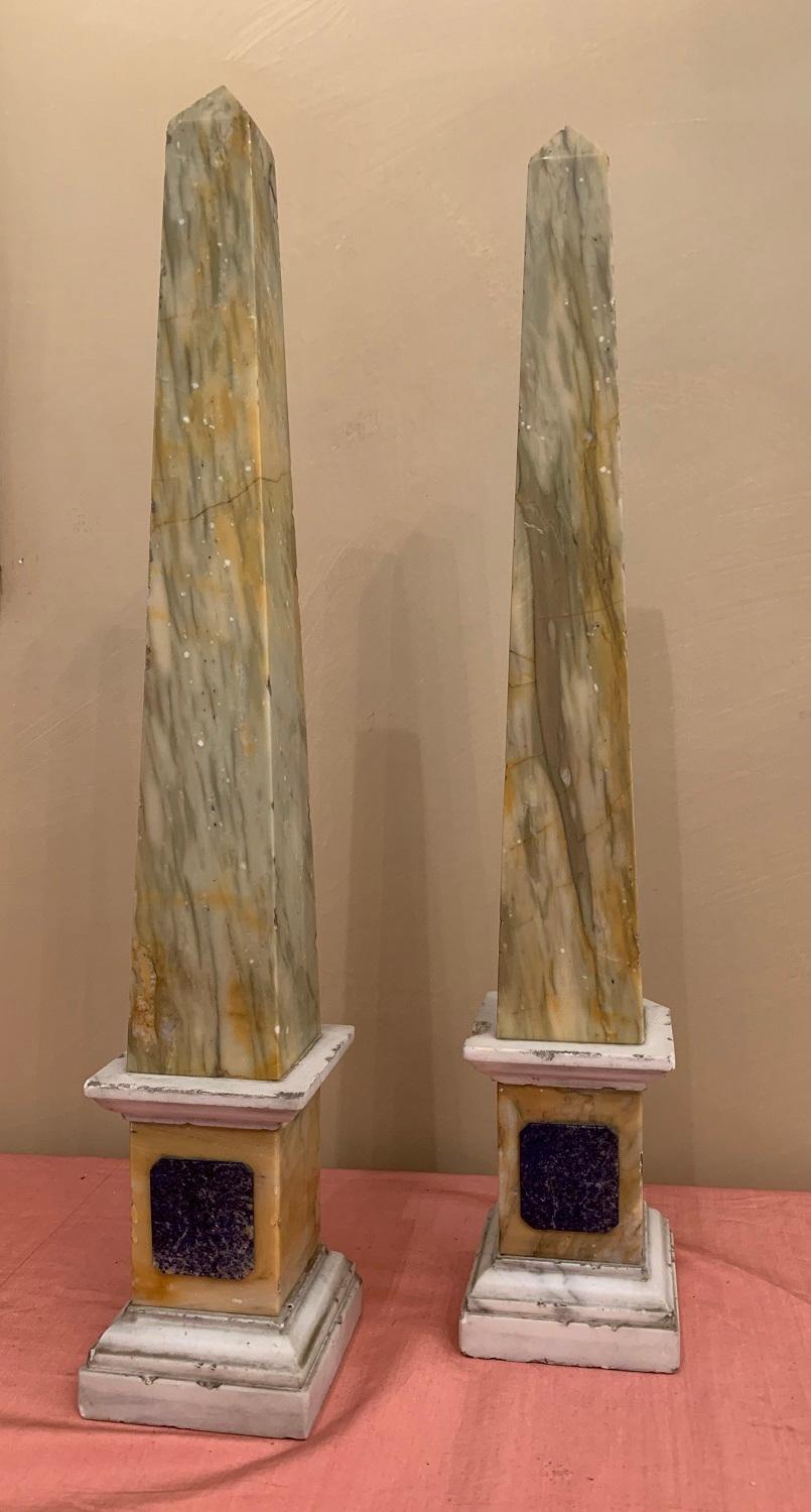 A pair of late 19th century Grand Tour Obelisks. The mouldings in Carara, the plint in Sienna, the plaque in Lapis Lazuli and the obelisks themselves in onyx.