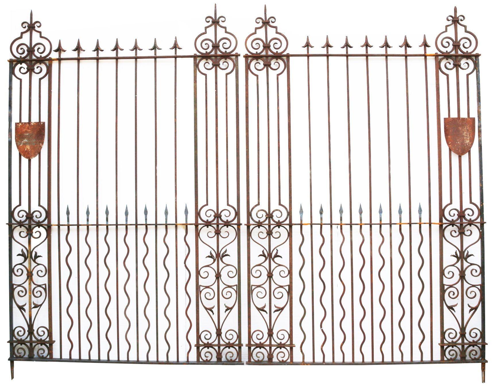 A pair of large 19th Century wrought iron driveway gates. Reclaimed from a house in Northamptonshire. The second image shows a pair of original decorative shields that are supplied with the gates, if required, though not fitted.

Additional