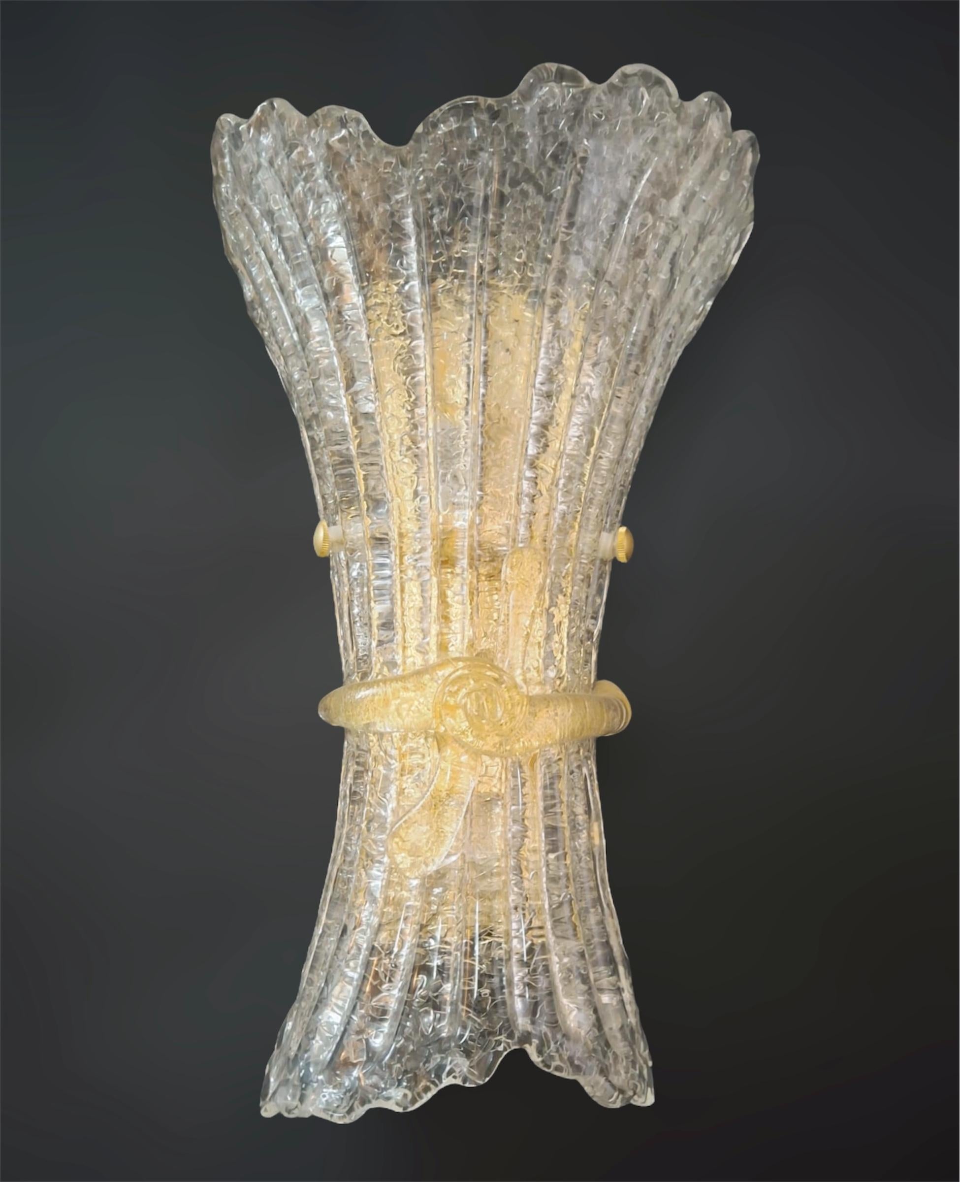 Italian wall light with a clear Murano glass shade hand blown with granular texture using Graniglia technique and amber glass bow, mounted on gold finish metal frame / made in Italy
Measures: height 15.5 inches, width 9 inches, depth 5.5 inches
2