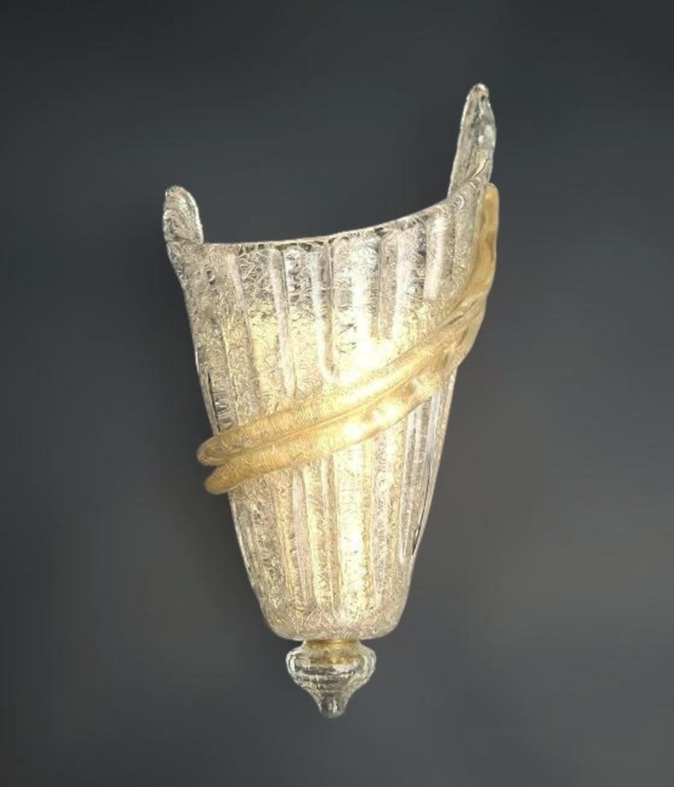 Italian wall light with a Murano glass shade hand blown in Graniglia technique to produce granular textured effect and a band infused with gold flecks, mounted on gold finish frame / Made in Italy circa 1960s
Measures: Height 13 inches, width 7