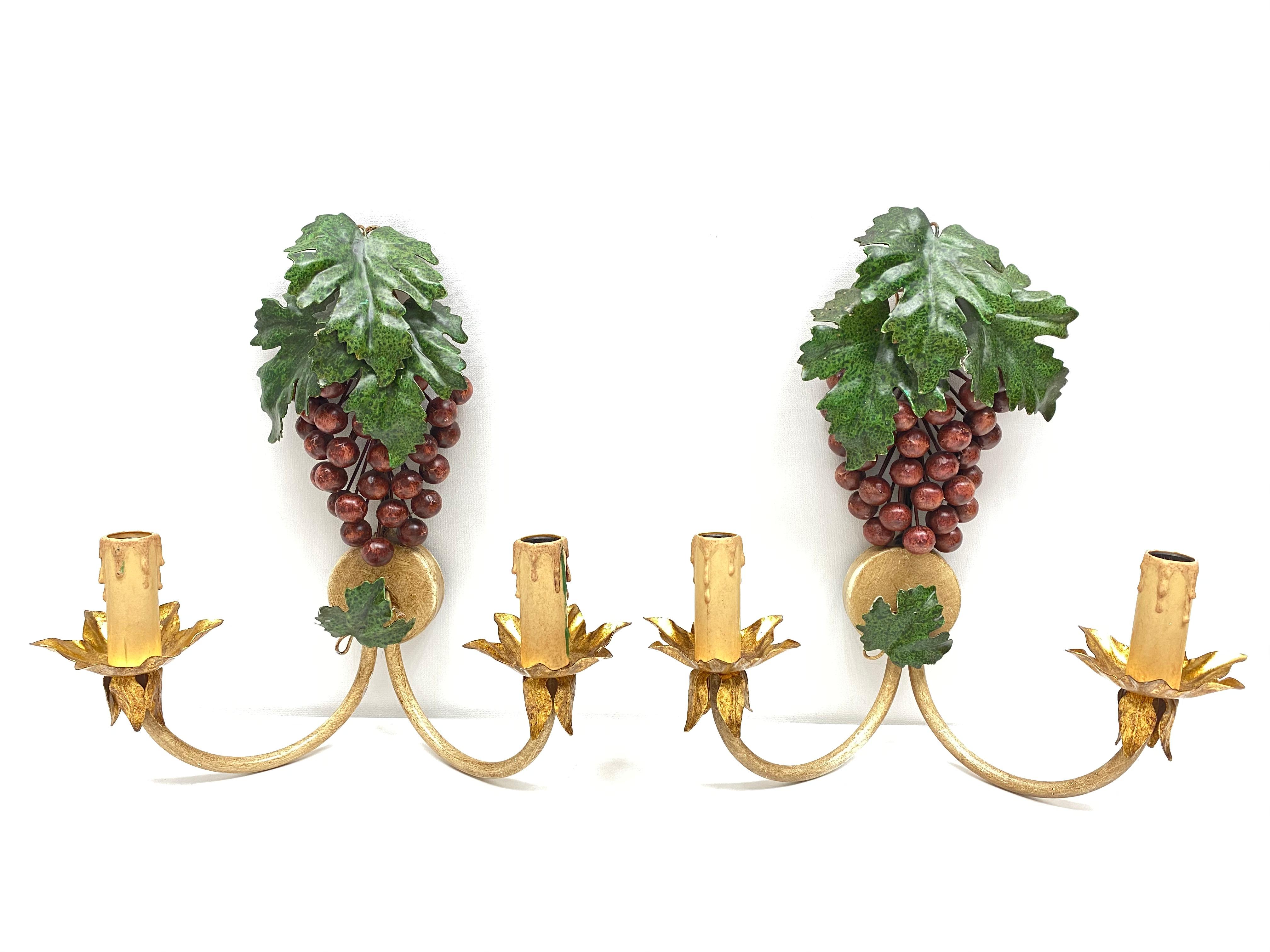A pair Hollywood Regency midcentury grape and leaf florentine sconces, each fixture requires two European E14 candelabra bulbs, each up to 40 watts. The wall lights have a beautiful patina and give each room a eclectic statement.