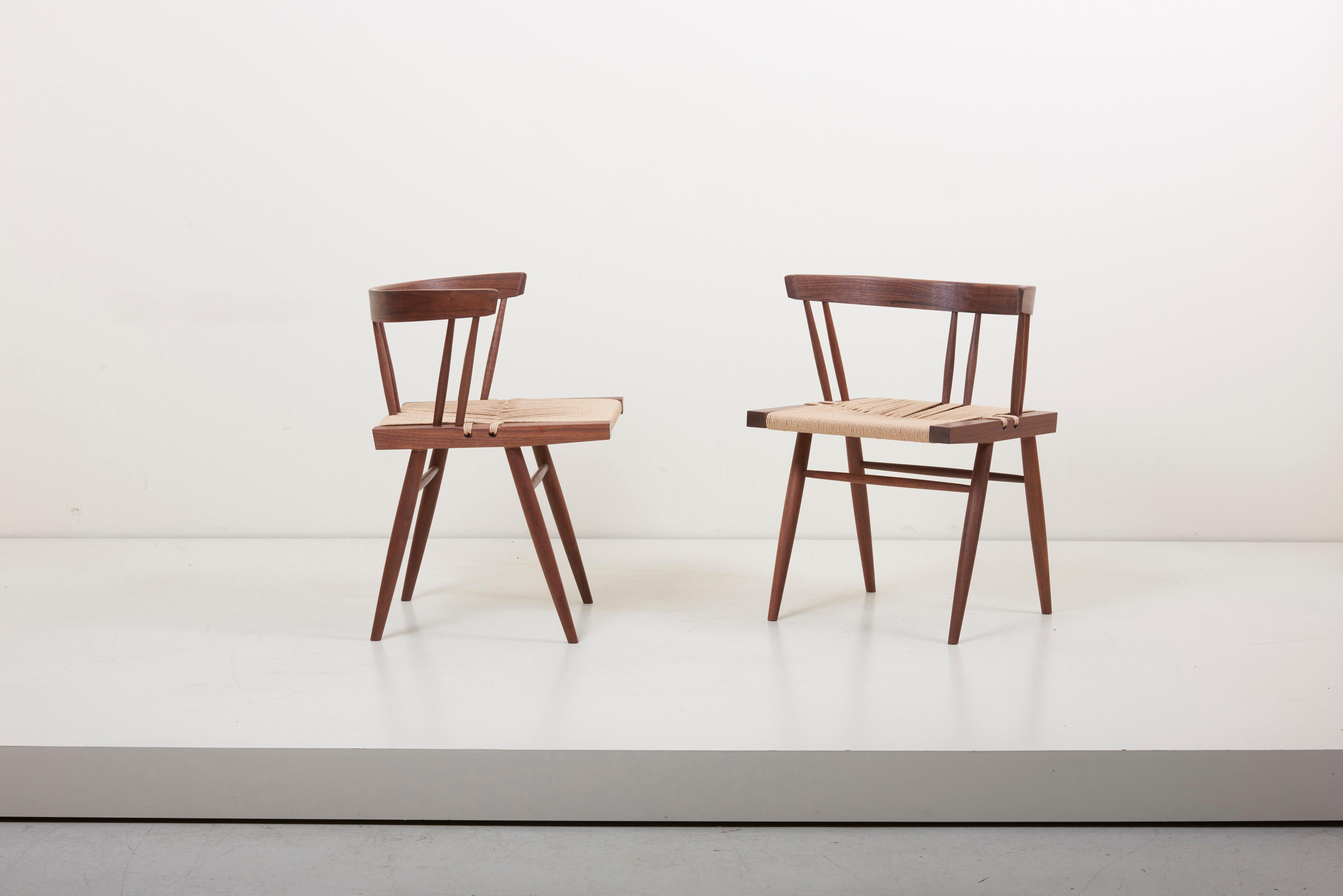 Pair of Grass-seated chairs, designed by George Nakashima and manufactured by George Nakashima Studio in the US. The square seat typically found in walnut and woven sea-grass. Outstanding quality.