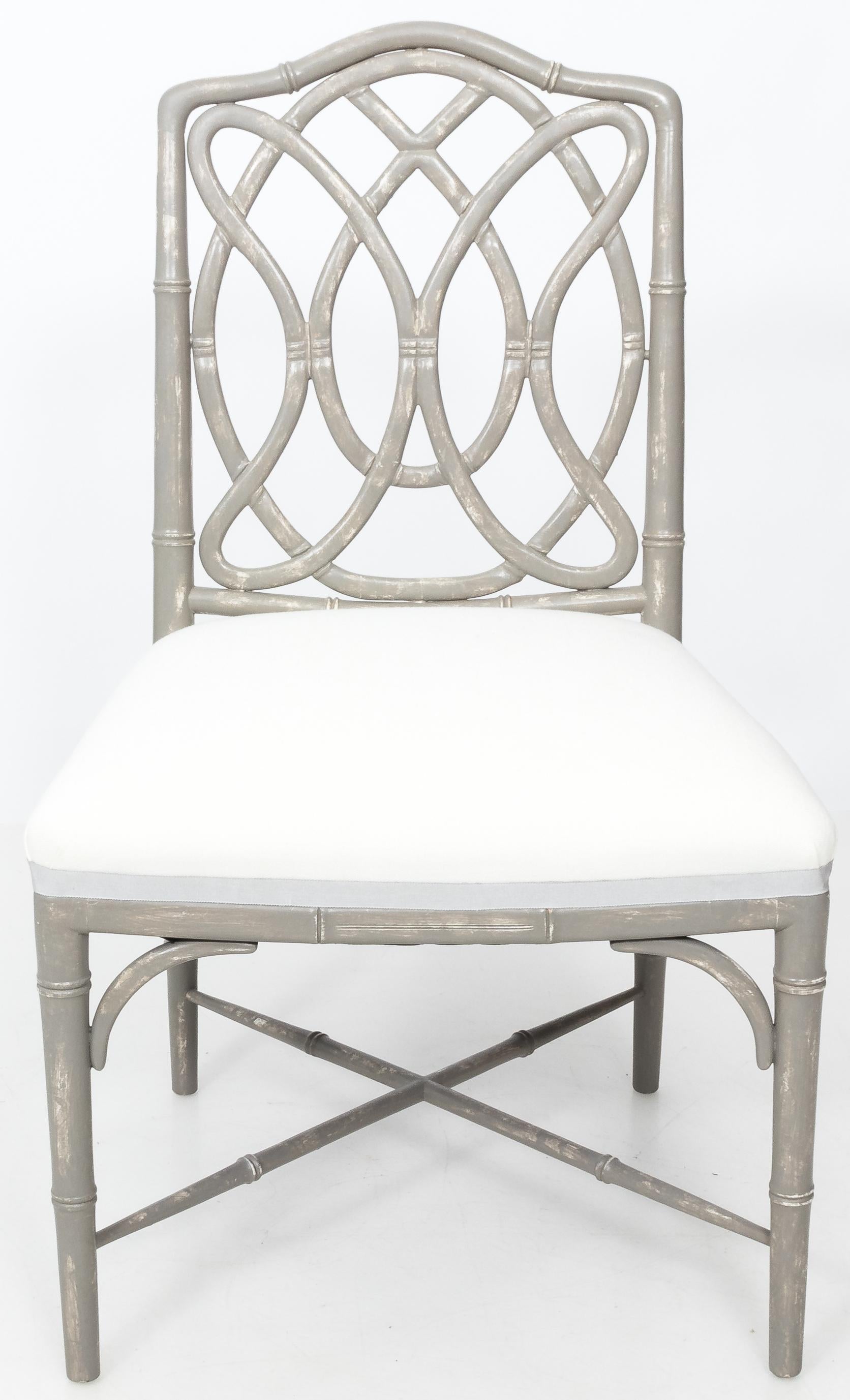 Ein Paar Esszimmerstühle aus Bambusimitat. Design mit Schlaufenrücken. Neu lackiert in antikem grauem Distress-Finish. Neu gepolstert mit weißem Leinen und grauem Bandbesatz.
Preis pro Paar. 4 Stühle verfügbar.