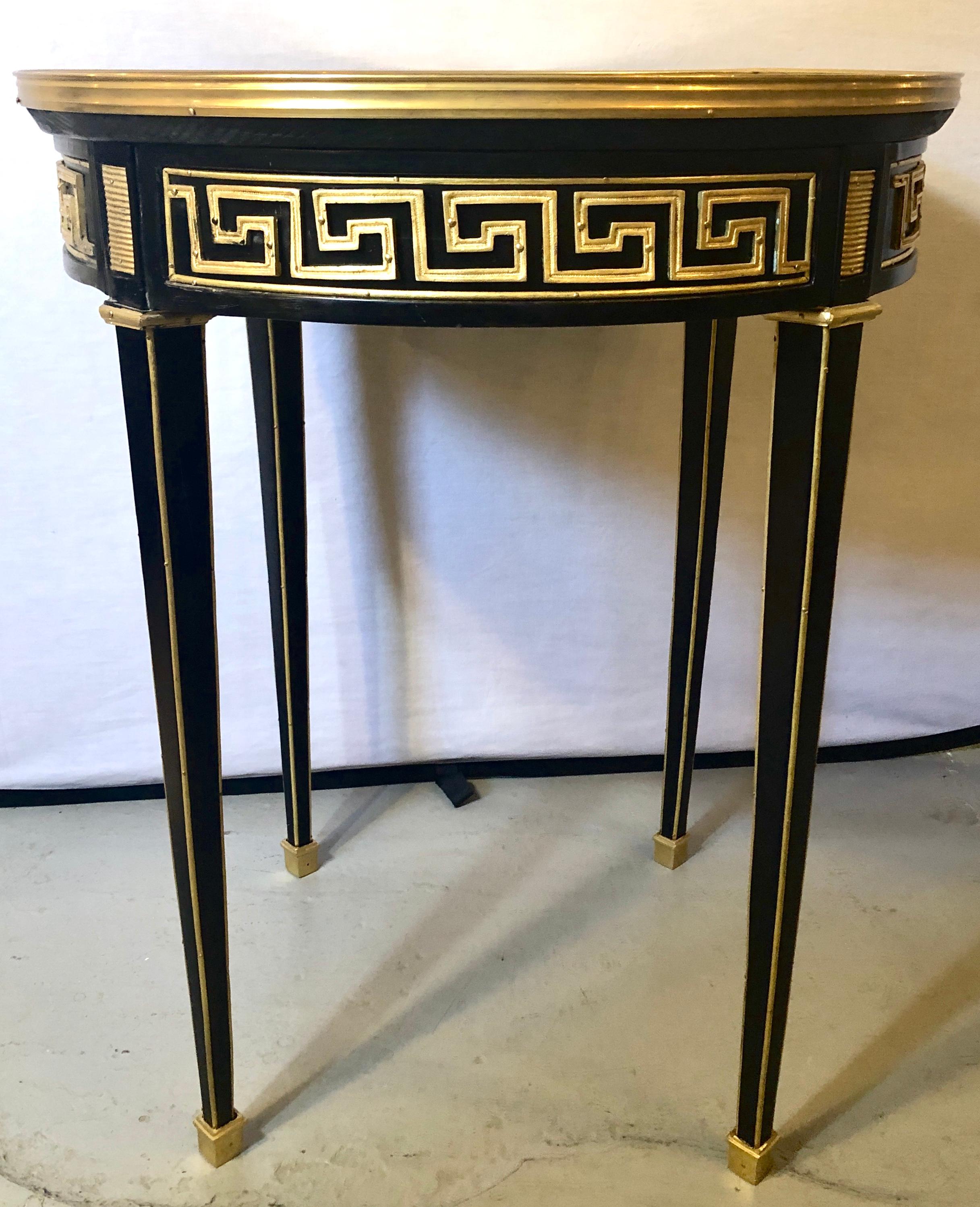 Pair of Greek key designed bronze galleried marble top ebony Bouillotte or pedestal tables. These are simply the most stunning pair of Hollywood Regency style end tables or pedestals on the market. The tapering legs having bronze sabots with bronze