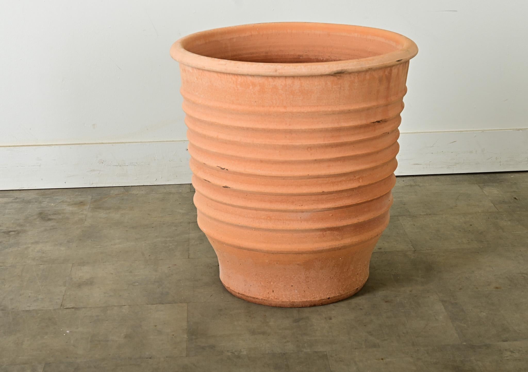 A pair of reproduction terracotta pots, or planter, made on the island of Crete, Greece using centuries if not millennia-old techniques to achieve their specialized forms decorated with raised, parallel rings. Based on ancient Minoan storage pottery
