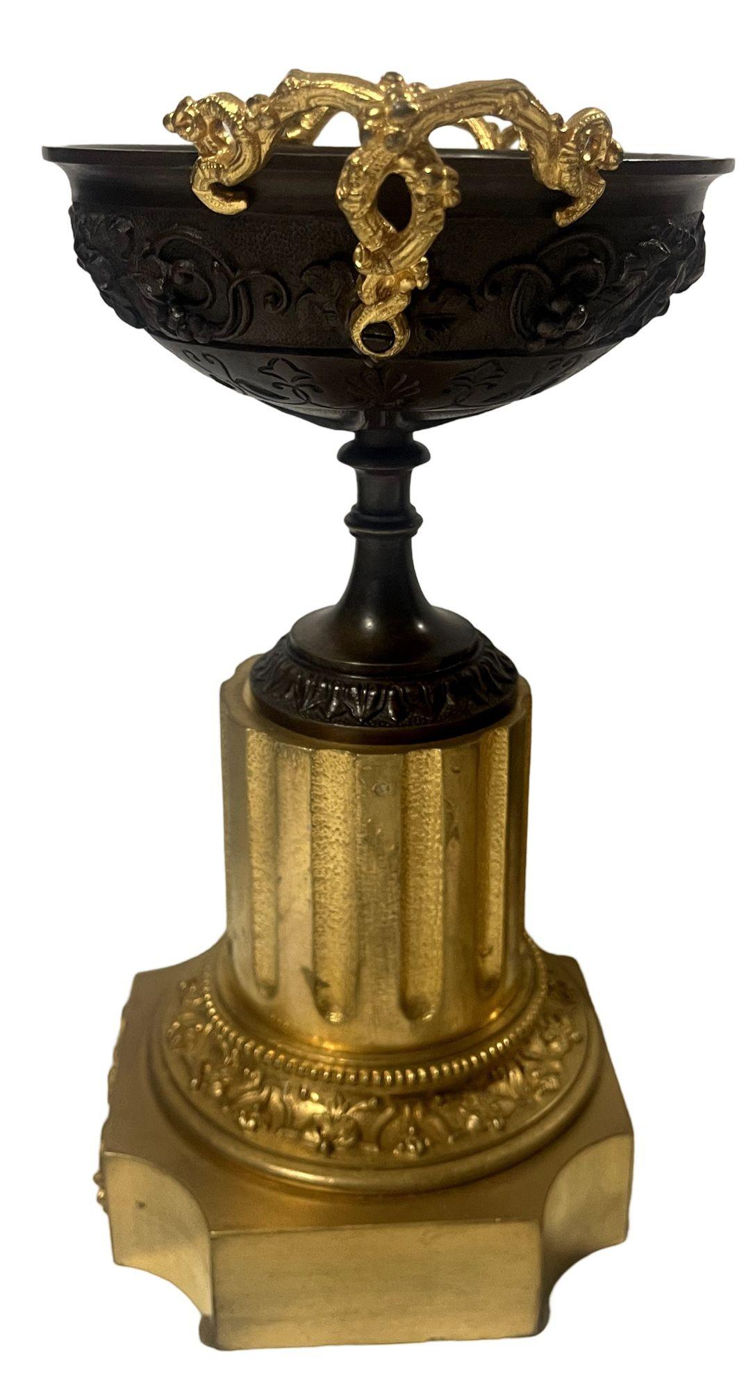 Questa elegante coppia di tazze francesi in bronzo della metà del XIX secolo di epoca greca mostra un'intricata lavorazione in stile neoclassico, con ciotole poco profonde ornate da dettagliati motivi baccanali in rilievo di uva e viti. Ogni ciotola