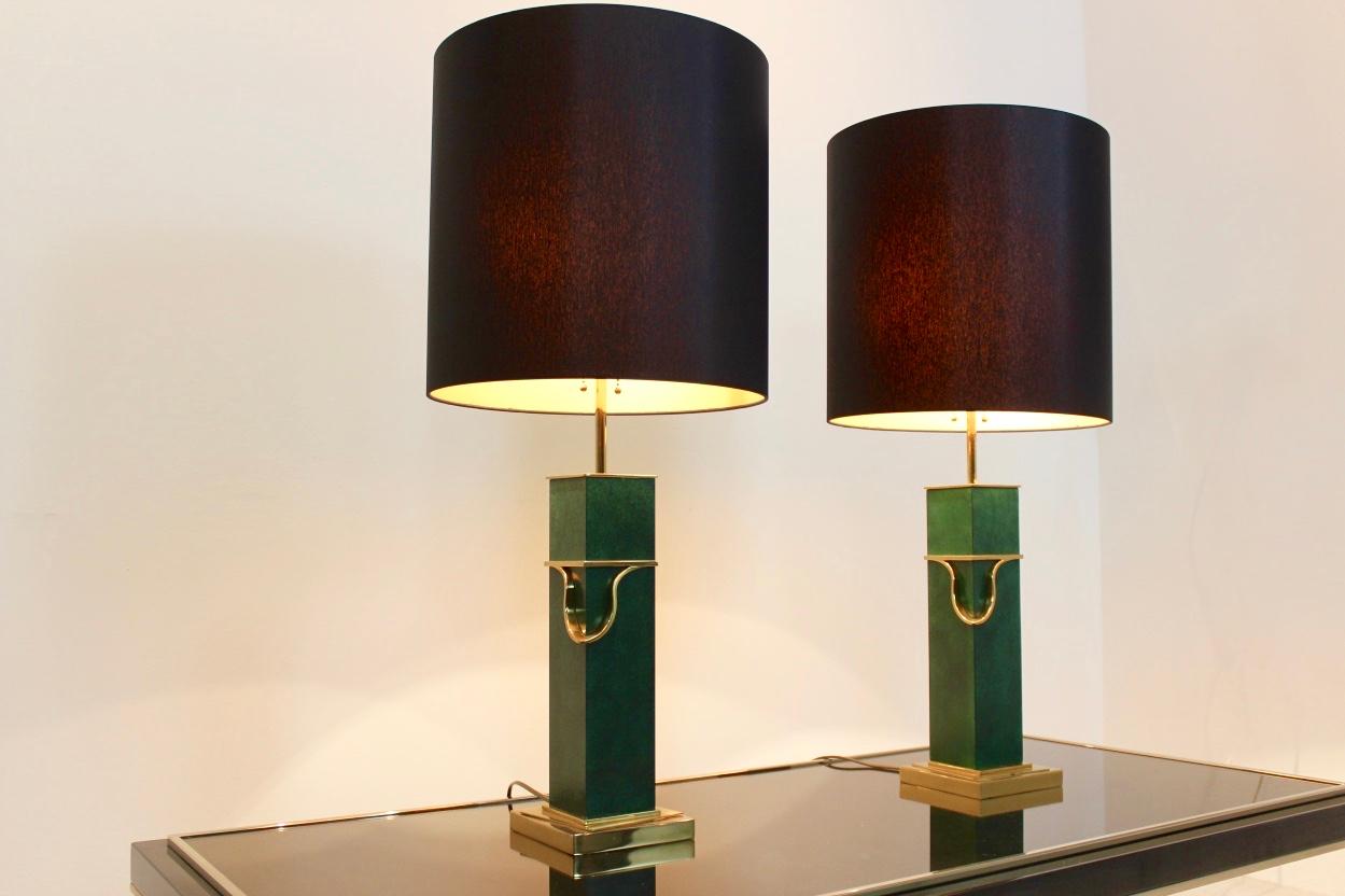 Sophisticated pair of midcentury table lamps from the 1970s.
The square brass bases combined with the classical look in green give these lamps their modern and sophisticated form. The set features new black circular shades which give a very warm