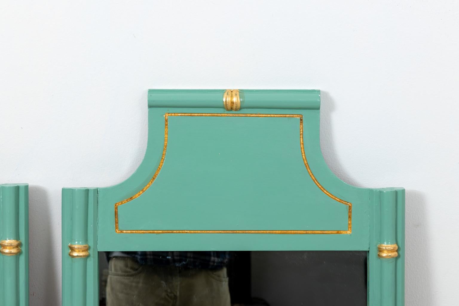 Pair of green and gold painted faux bamboo wall mirrors with angled crown. Please note of wear consistent with age including minor paint loss.