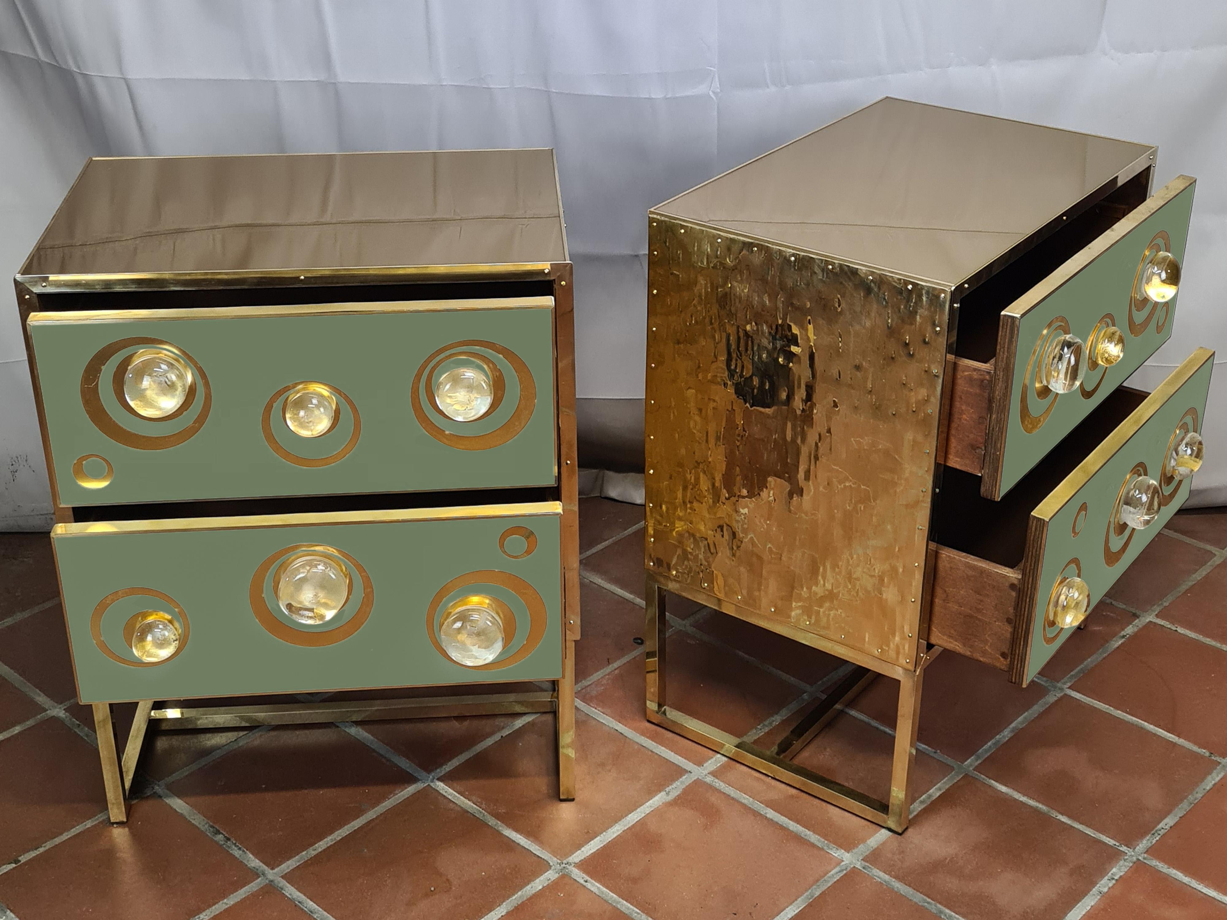 Pareja de mesillas de noche de cristal de murano verde hechas a mano en italia.

Estas hermosas piezas presentan madera de abedul pulida adornada con esferas enjoyadas de cristal de Murano adornadas con aros de latón para realzar el estilo. 

Los