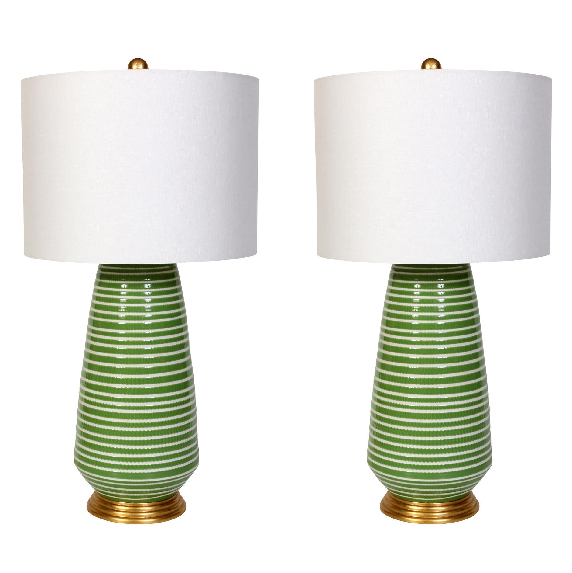 A pair of ceramic lamps in a cheerful green and white stripe  on a gold  base  with linen shades.  Ready to add some personality to a bedroom, living room or  family room! Priced individually, but a pair is available. Please note price listed is per