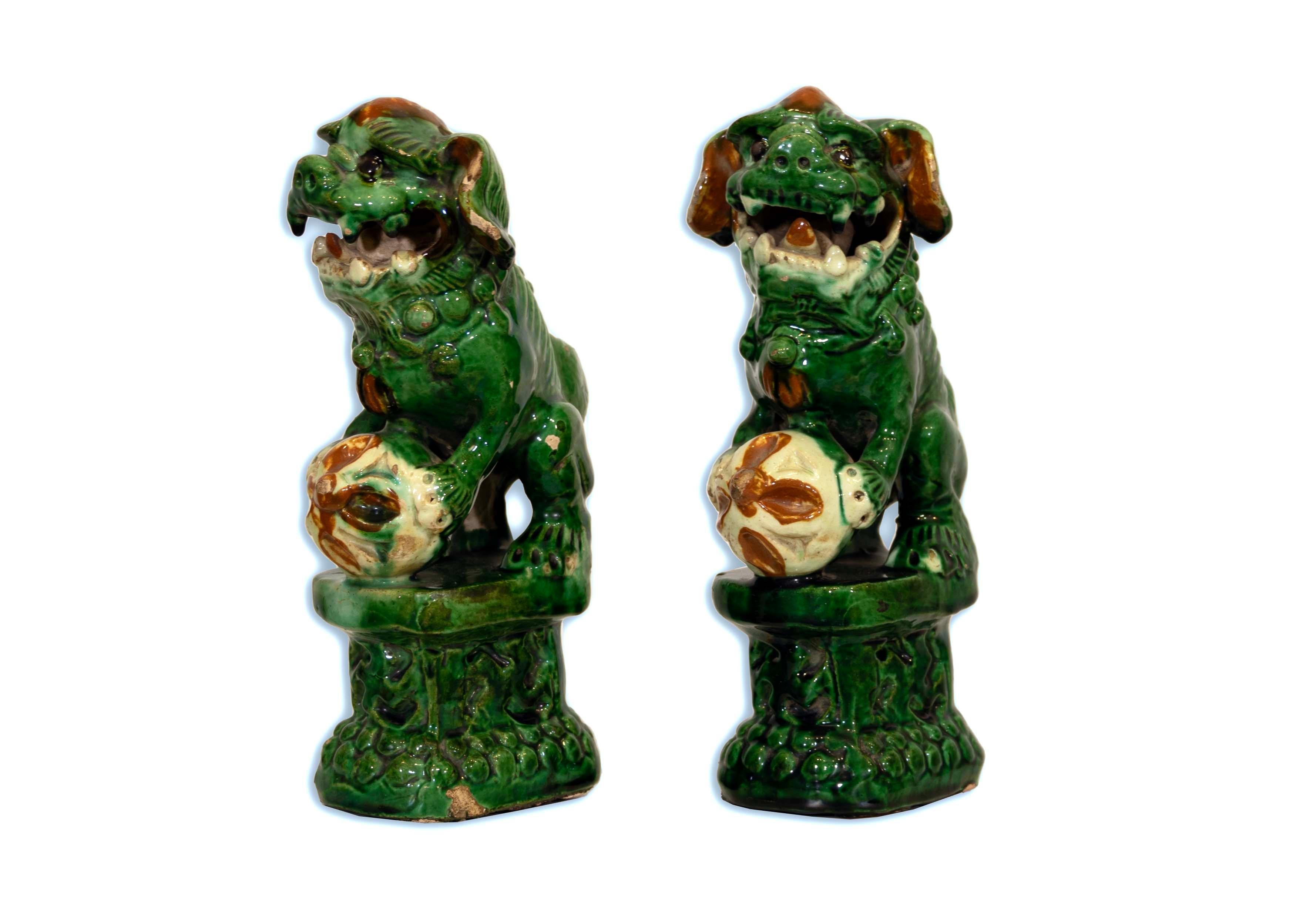 This exquisite pair of green Chinese Sancai-glazed Fu Dogs from circa 1900 is a stunning representation of historical artistry. With their vibrant emerald hues and tri-color detailing, these guardian figures radiate with an antique charm that adds a