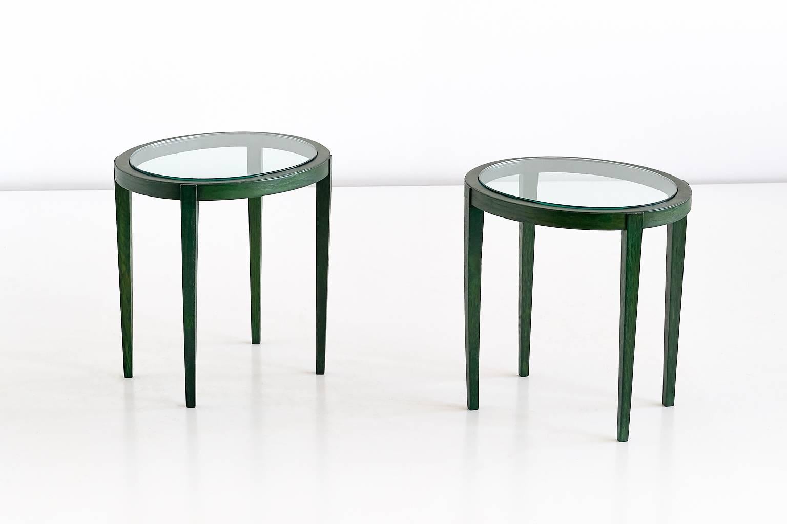 This pair of green side tables was a custom design for a private palazzo residence in Florence. Made in the late 1930s, the tables were part of a dining room which had an entirely green decor. 
The table is executed in a solid elm wood with an oval