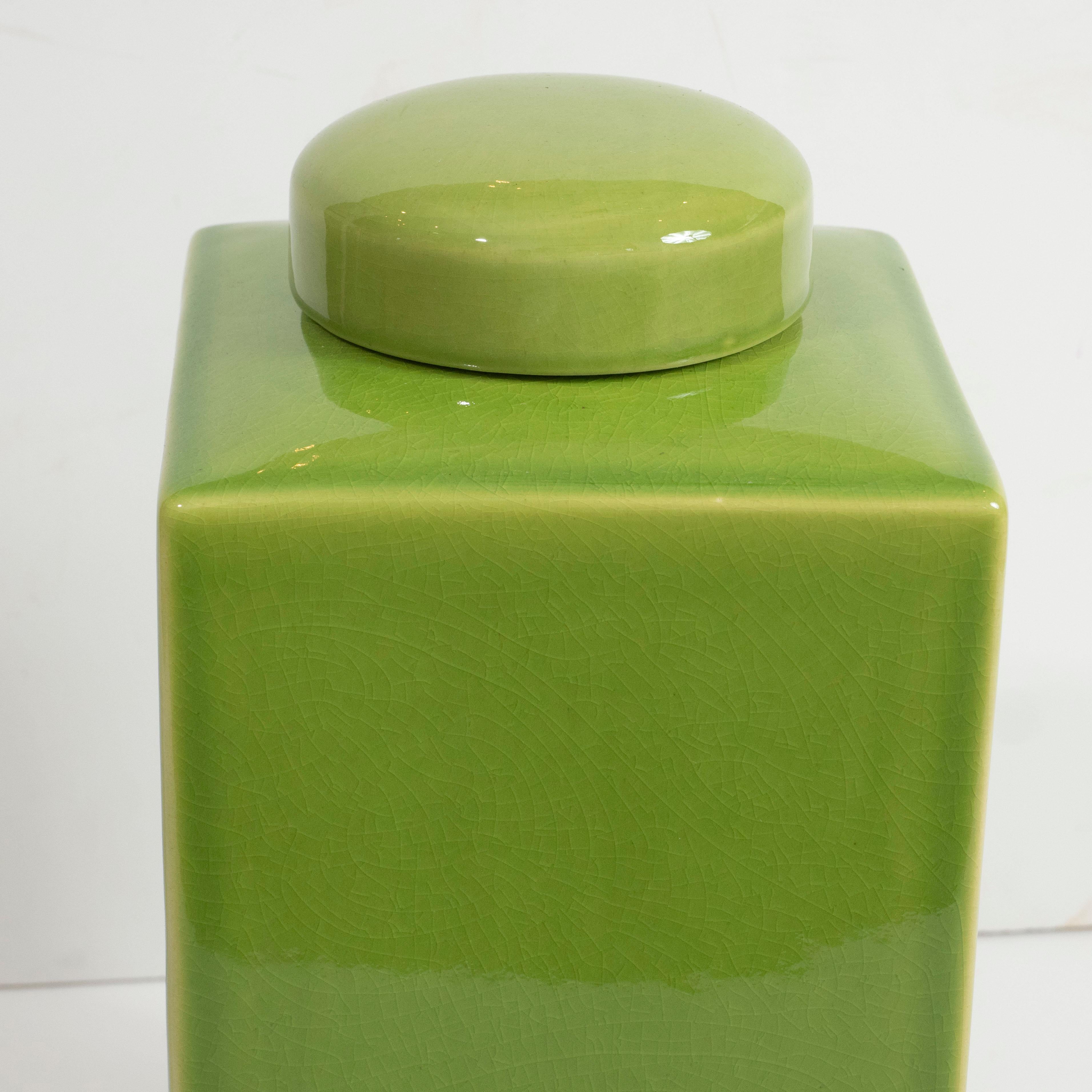 A pair of decorative, square ceramic jars with lids in a stunning apple green.