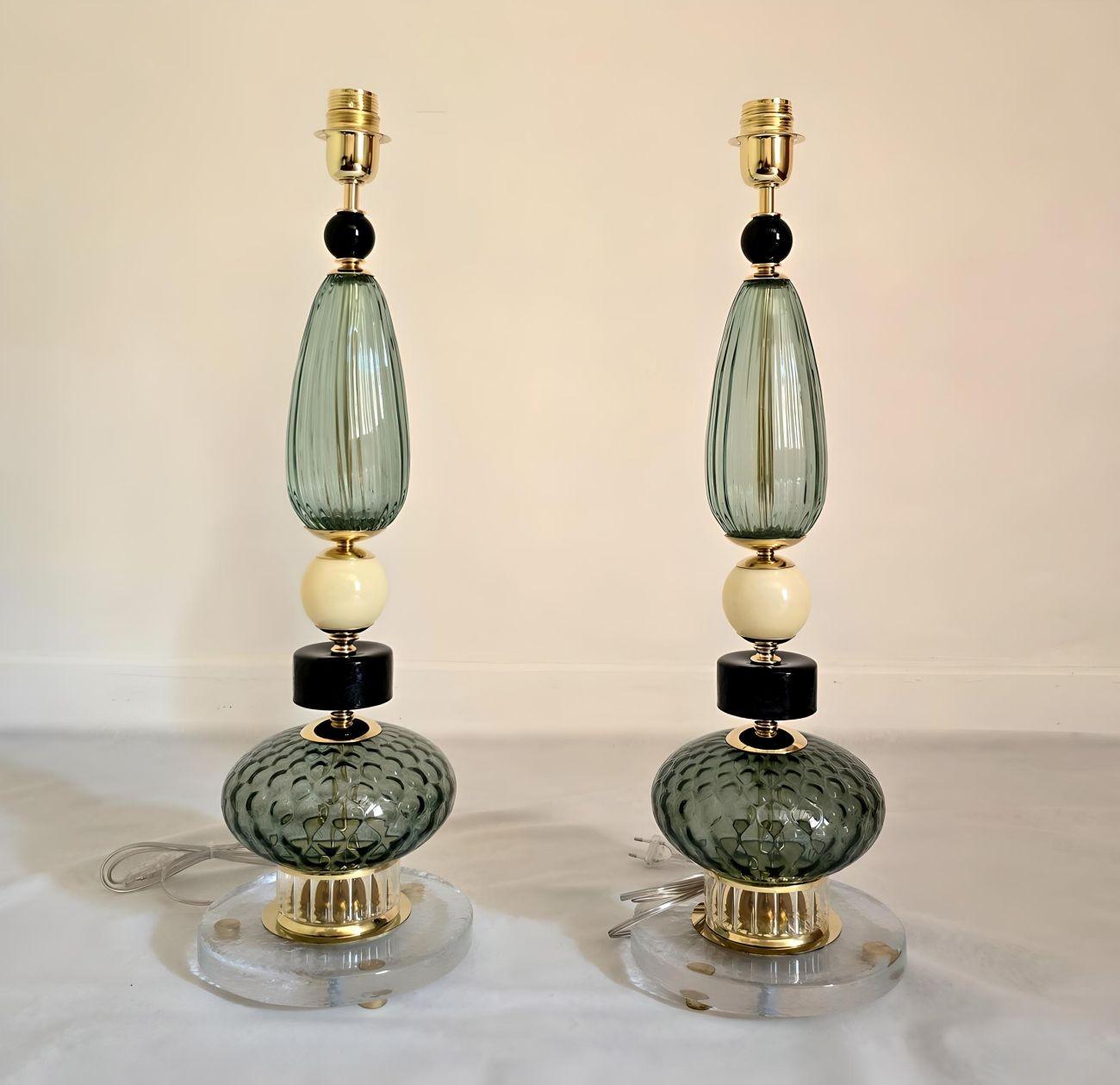 Coppia di lampade da tavolo in vetro di Murano della metà del secolo scorso, Italia, circa anni '80.
Le lampade italiane sono composte da vari elementi in vetro di Murano lavorato a mano, con montature in ottone.
La base delle lampade è in un solido