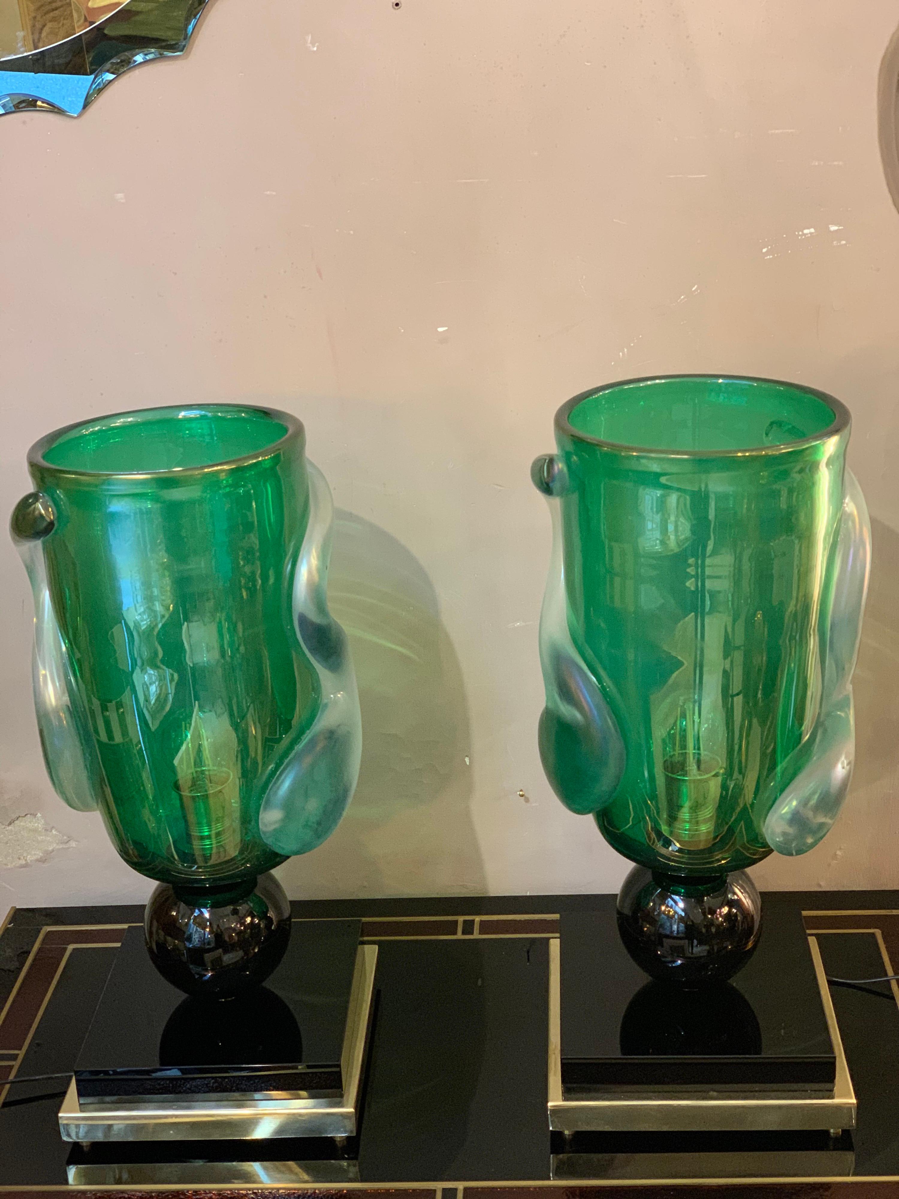 Pair of green hand blown Murano glass table lamps by Costantini Murano.
The body of the lamp is decorated with spiral freeform iridescent reliefs.
The base is made of brass and black Murano glass. One bulb each lamp.
The base measures: cm 25 x