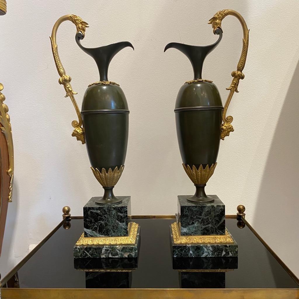 Pair of 1st Empire aiguieres by sculptor Ravrio ( 1759 - 1814 ) in green patinated bronze and gilded bronze, the base is in sea-green marble.

Of elongated baluster form, the necks and bases of these ewers are mounted with stylized palmettes, the