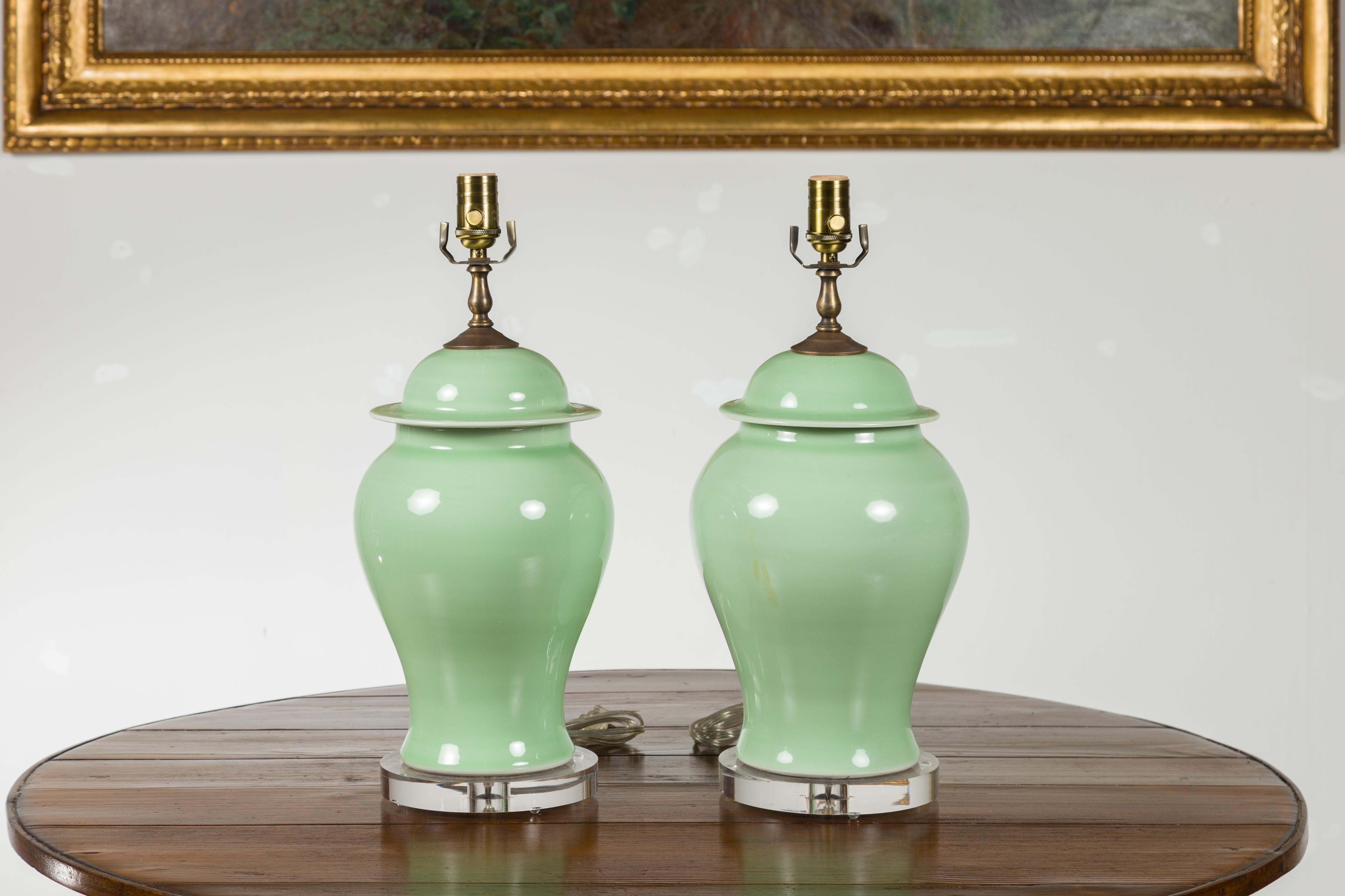 Pair of Green Porcelain Lidded Jar Table Lamps with Round Lucite Bases, Wired In Good Condition For Sale In Atlanta, GA