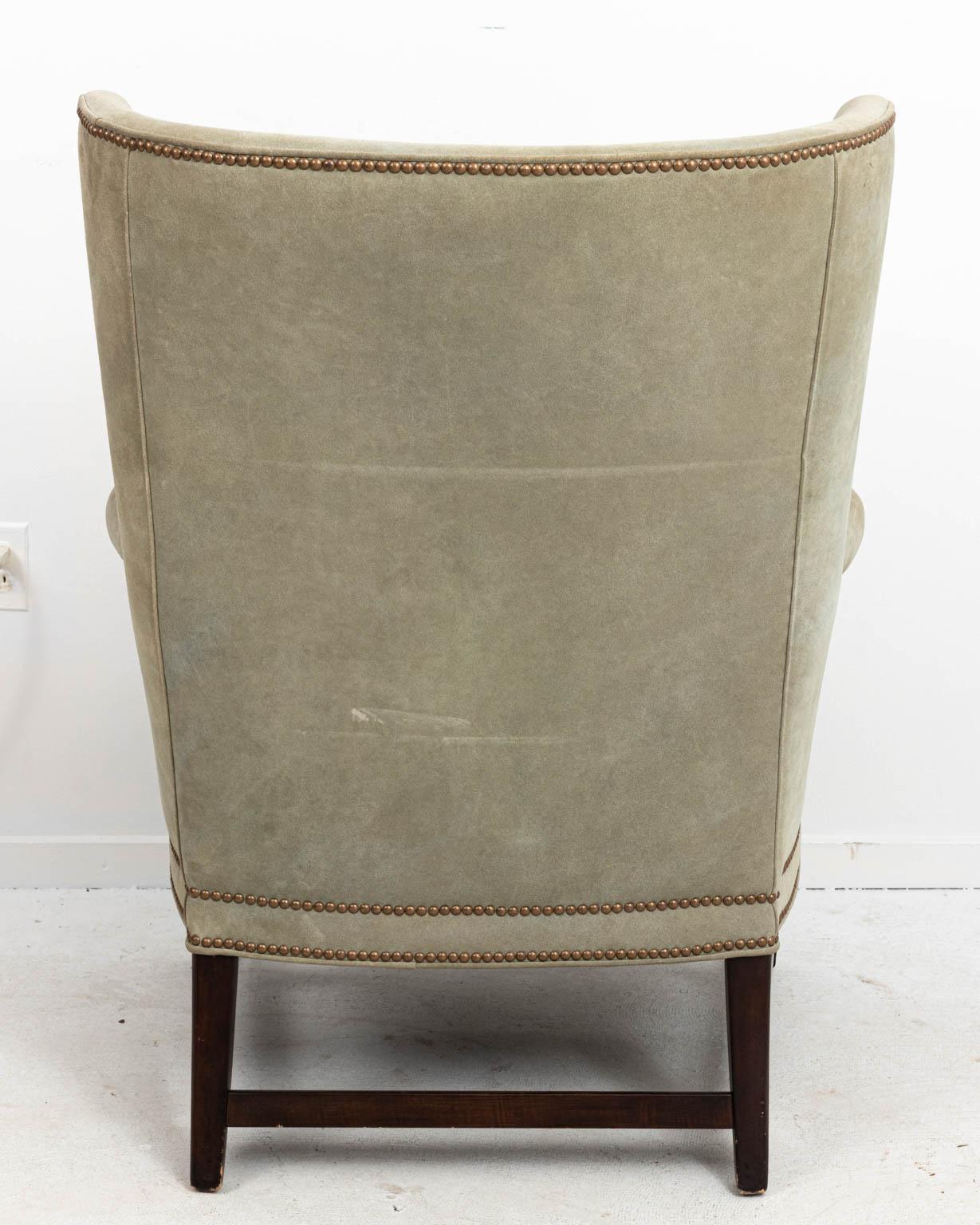 Contemporary pair of green suede upholstered wing back armchairs with tufted backs and metal nail head trim. Please note of wear consistent with age. Made in the United States.