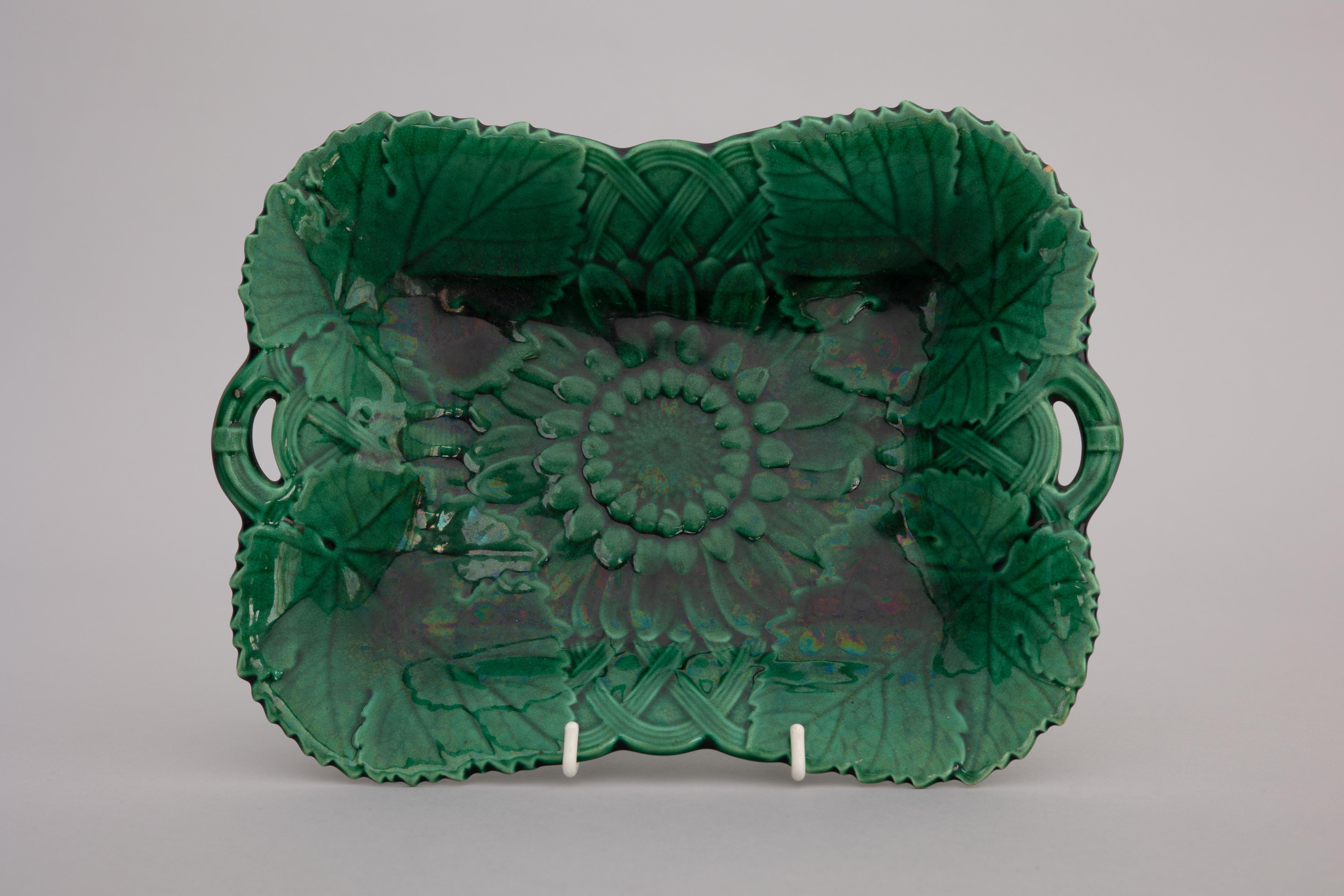 Pair of green majolica glazed serving dishes in the ‘Sunflower’ pattern by Wedgwood, made 1872.

The sunflower, alongside the calla lily and peacock feather, became an emblem of the late nineteenth-century Aesthetic Movement. Oscar Wilde became an