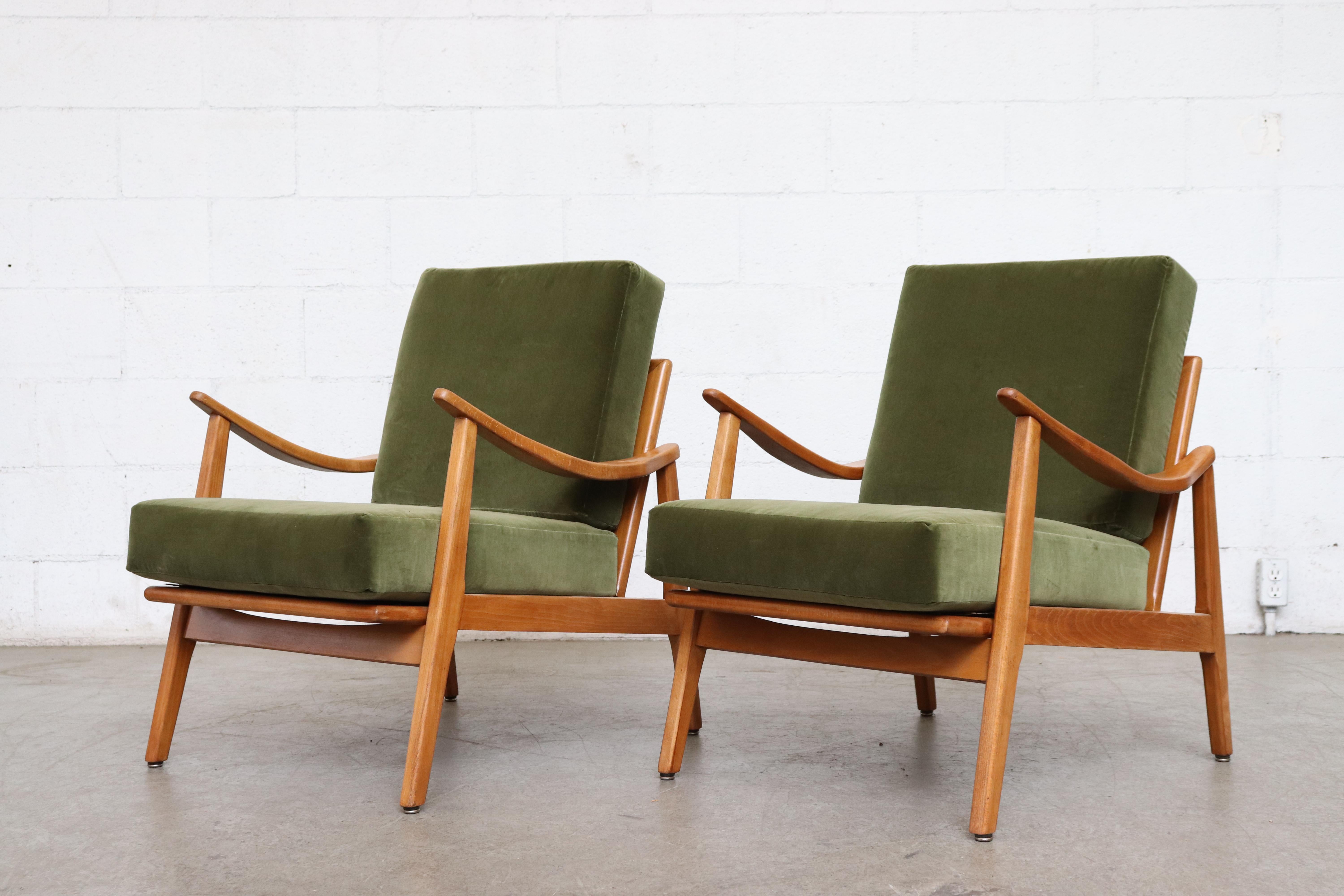 Pair of Danish midcentury lounge chairs. Newly upholstered in green velvet with lightly refinished wood frames. Naturally bent armrests and spindle backs. Set price. Other similar sets available, listed separately.