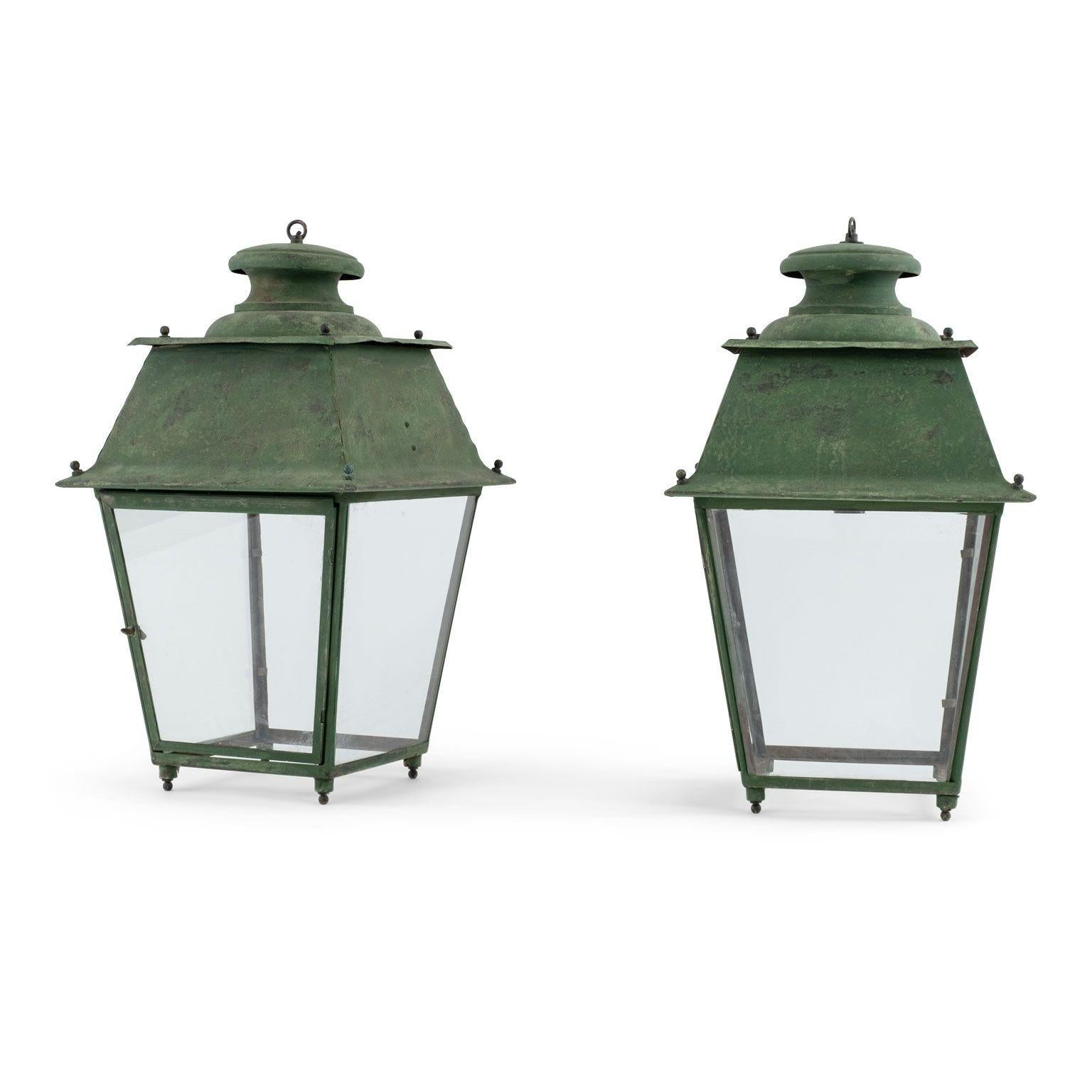 Pair of green-verdigris copper French lanterns, circa 1880-1919. Copper, tole and iron lantern with four glass paneled sides. Originally used as street or outdoor lanterns - now unwired. Can be wired, or fitted for use with gas, for additional cost.