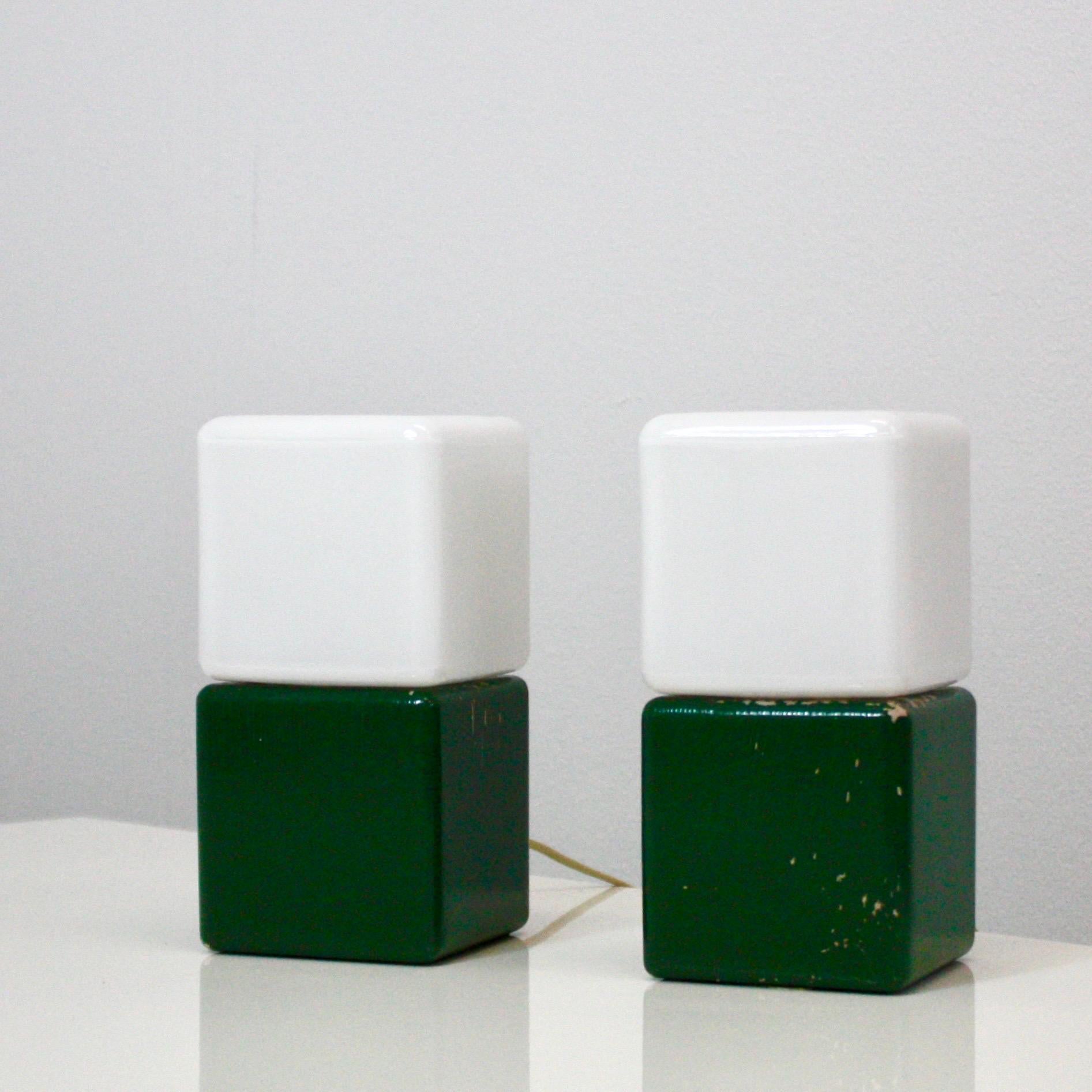 A pair of rare night lamps designed by designer Svend Aage Holm Sørensen in the early 1960s. The lamps feature green wood bases and white glass shades in cubic shapes.

* A pair (2) of green wood and white glass cubic night/desk lamps
* Designer: