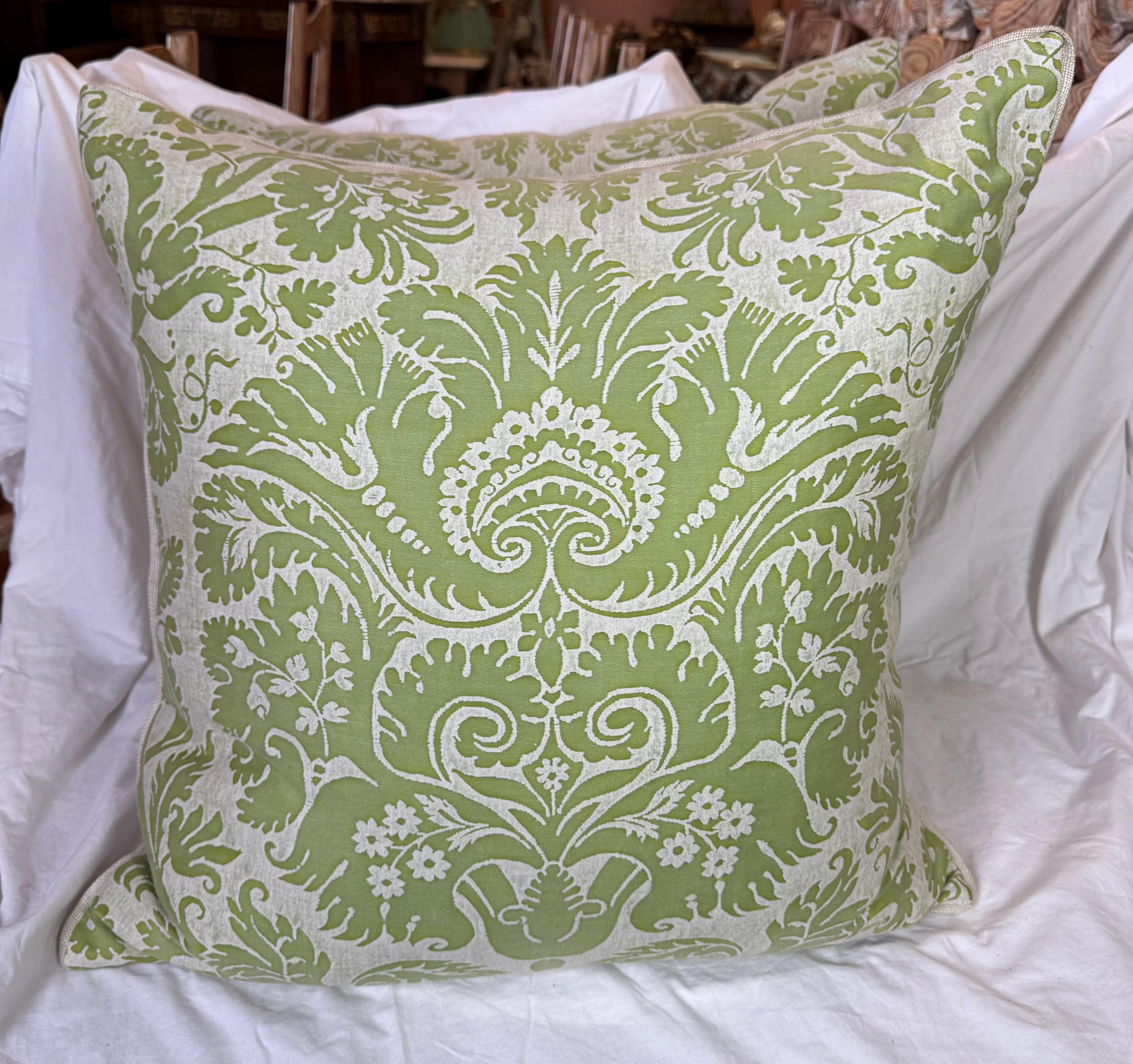 These pillows showcase an elegant Fortuny textile front, featuring a classic damask motif in fresh green and white. The intricate design evokes old-world charm with a refined, contemporary twist, printed on luxurious cotton fabric known for its rich