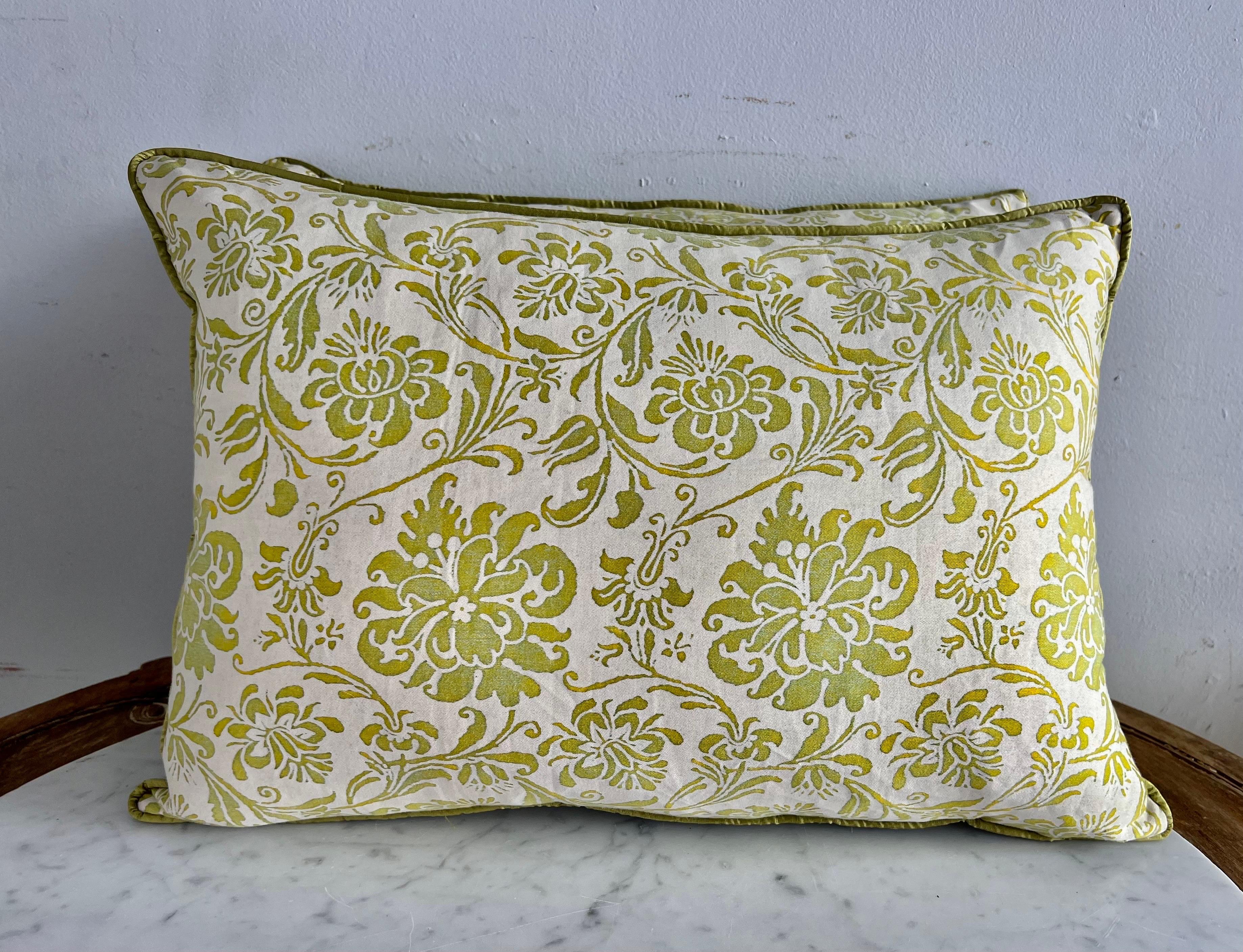 Pair of custom pillows made with green & white Fortuny textile fronts and green silk backs. Pattern depicts swirling flowers throughout. Self cord detail. Sewn closed.