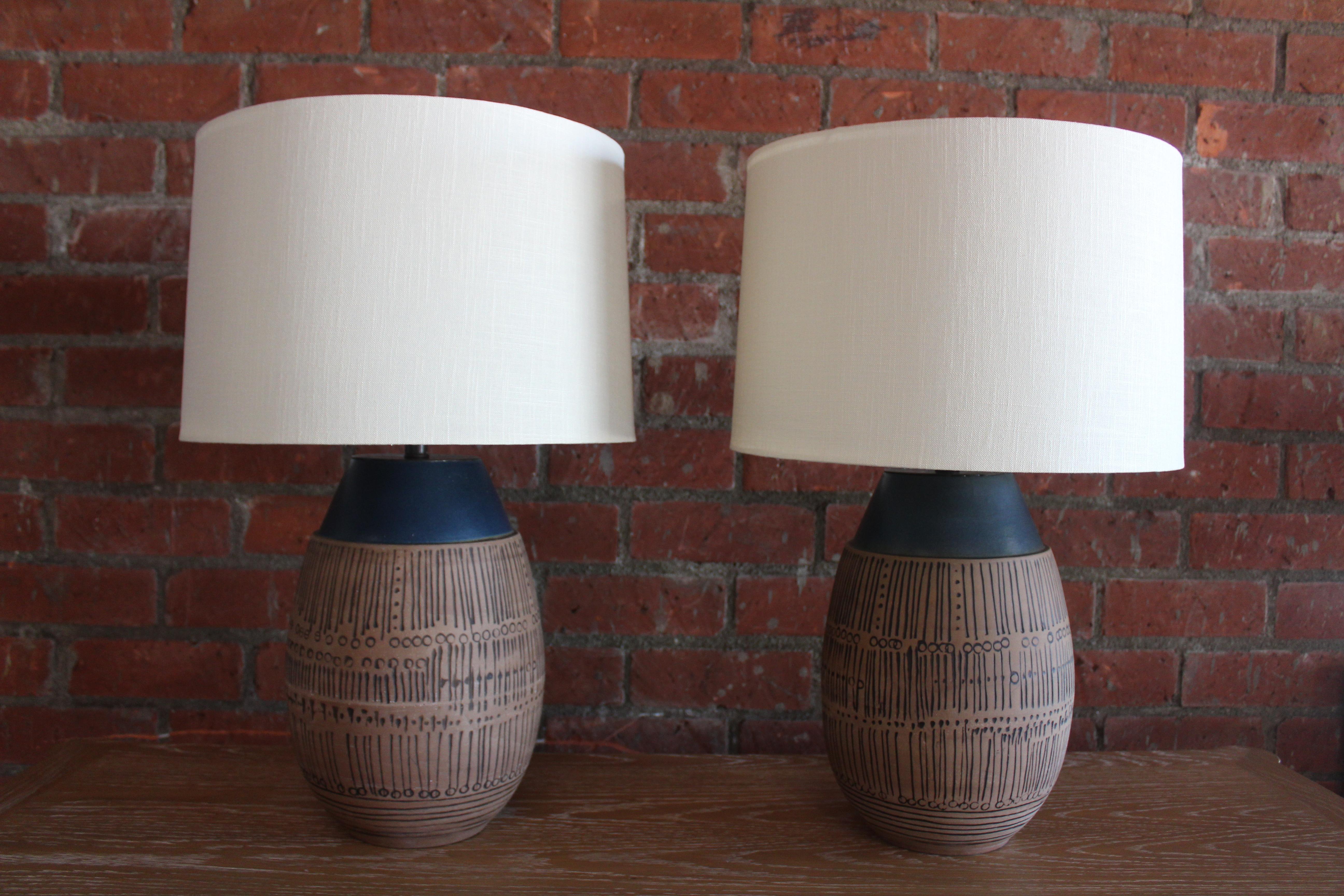 Pair of vintage 1960s chamotte stoneware table lamps by Lisa Larsen, Sweden. The pair have been recently rewired and fitted with custom shades made of Belgian linen. They are 26.5 high with shades and have a 11