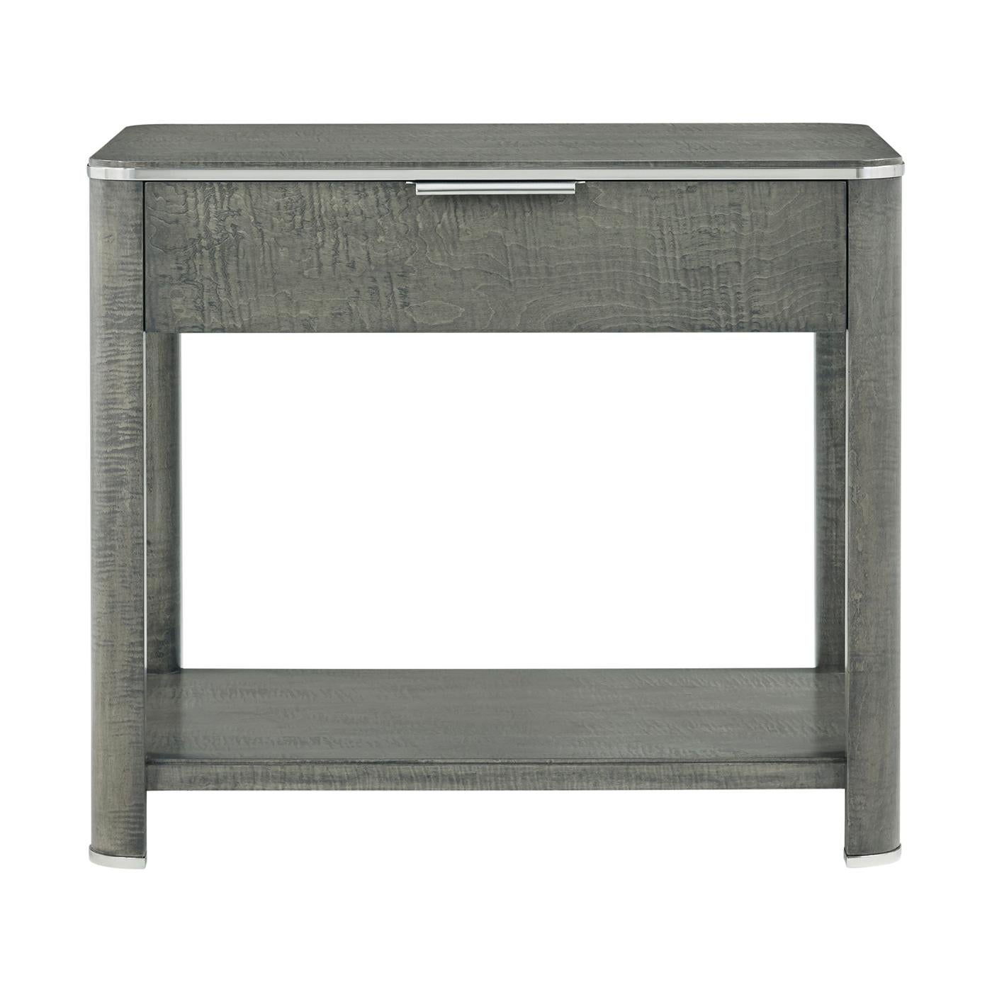 Cette pièce élégante présente une combinaison étonnante de placages de chêne, d'acier inoxydable et d'érable, ce qui en fait un ajout raffiné à la décoration de toute chambre à coucher. La finition Pebble Grey ajoute une touche de modernité tout en