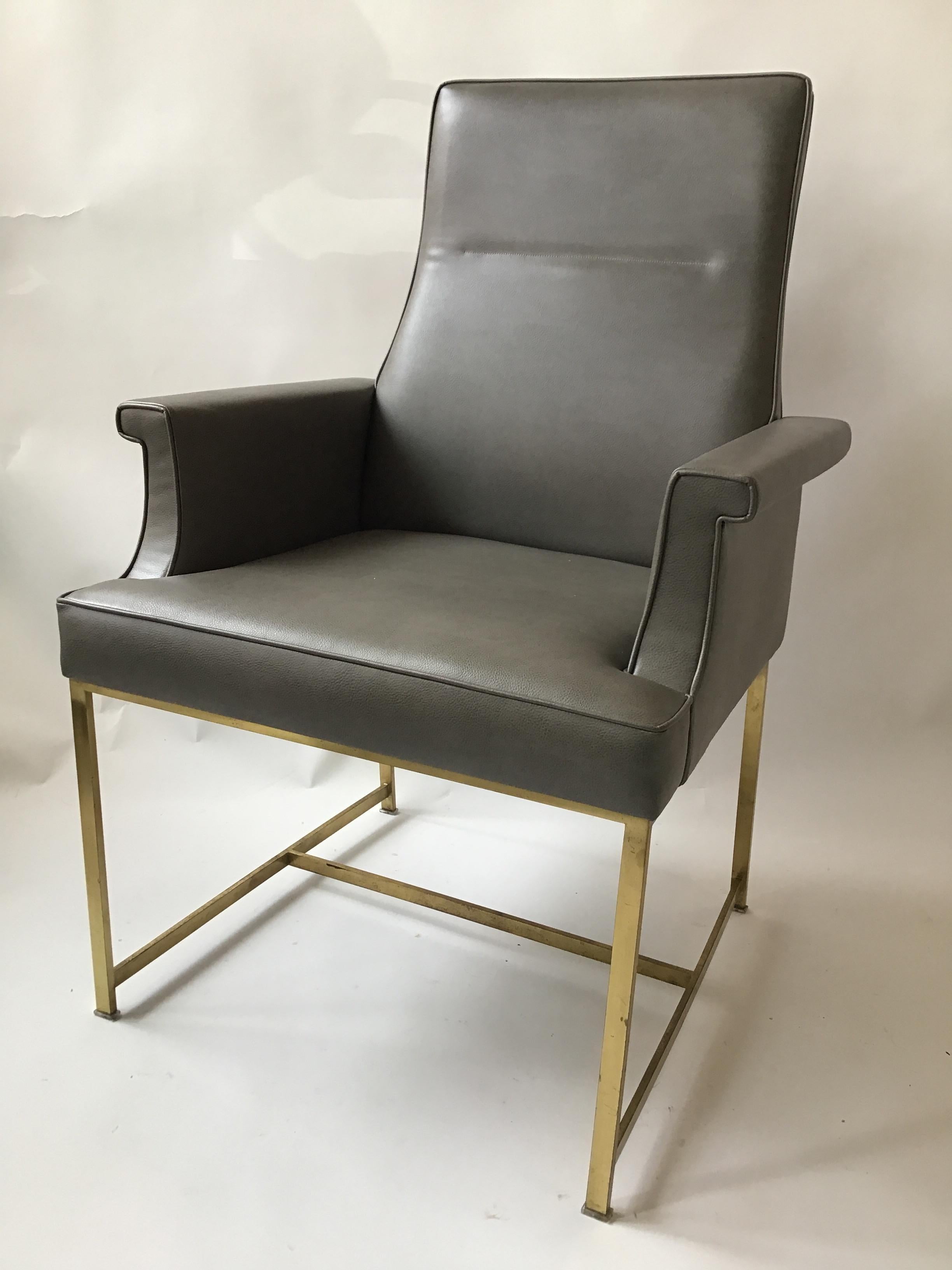 Pair of grey leather armchairs on brass bases. Well made. From a Southampton, NY estate.