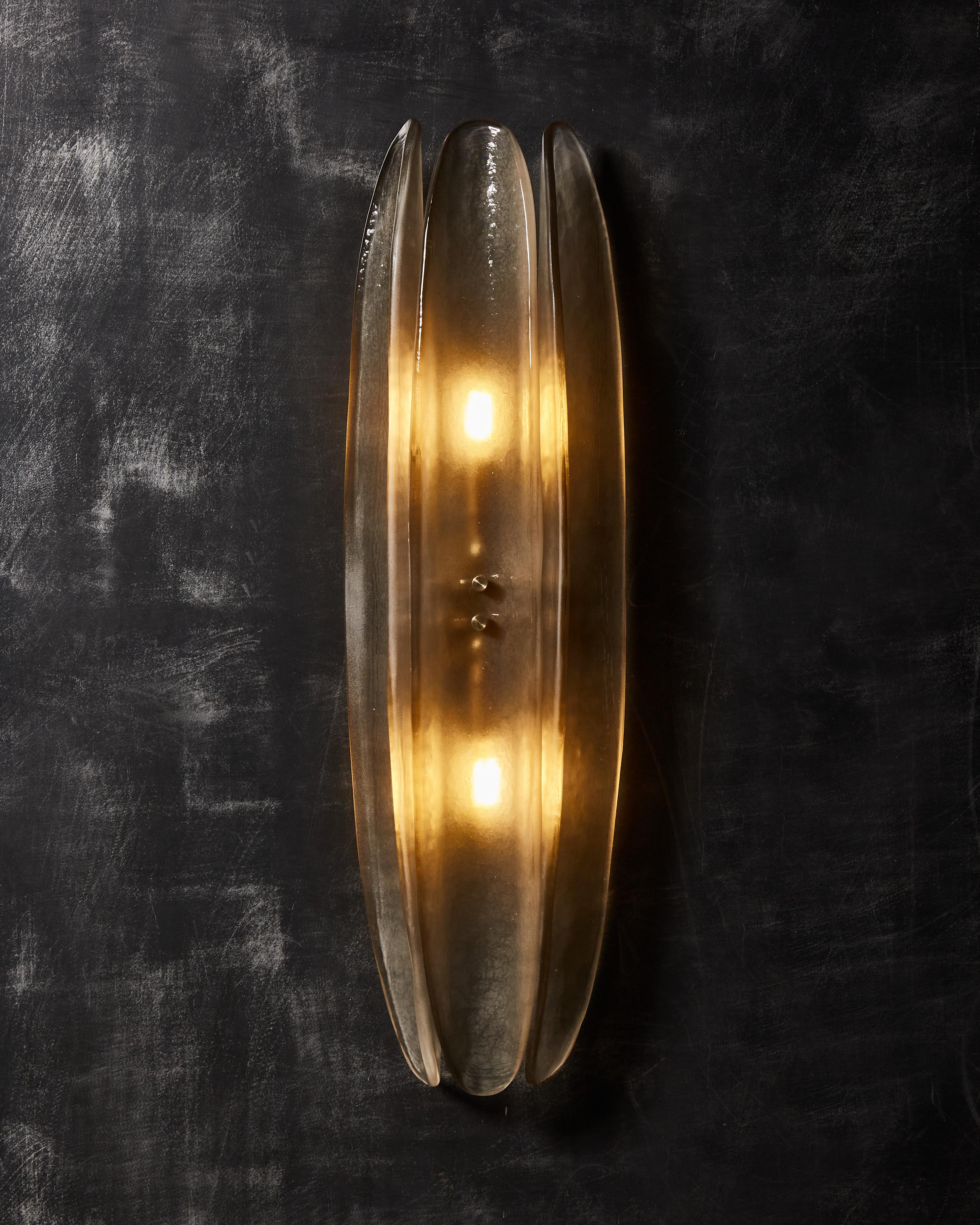 Pair of wall sconces made of three Murano glass elongated parts with brass settings.