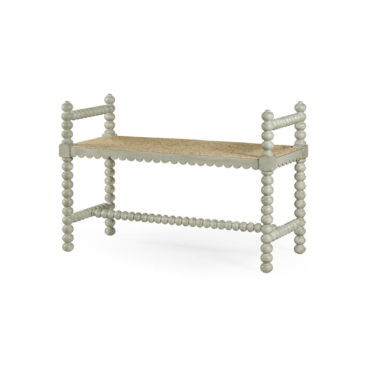 A modern Jacobean single bench constructed of acacia and finished in pale grey paint with a fine rush seat is perfect at the foot of a bed. 

Dimensions: 38