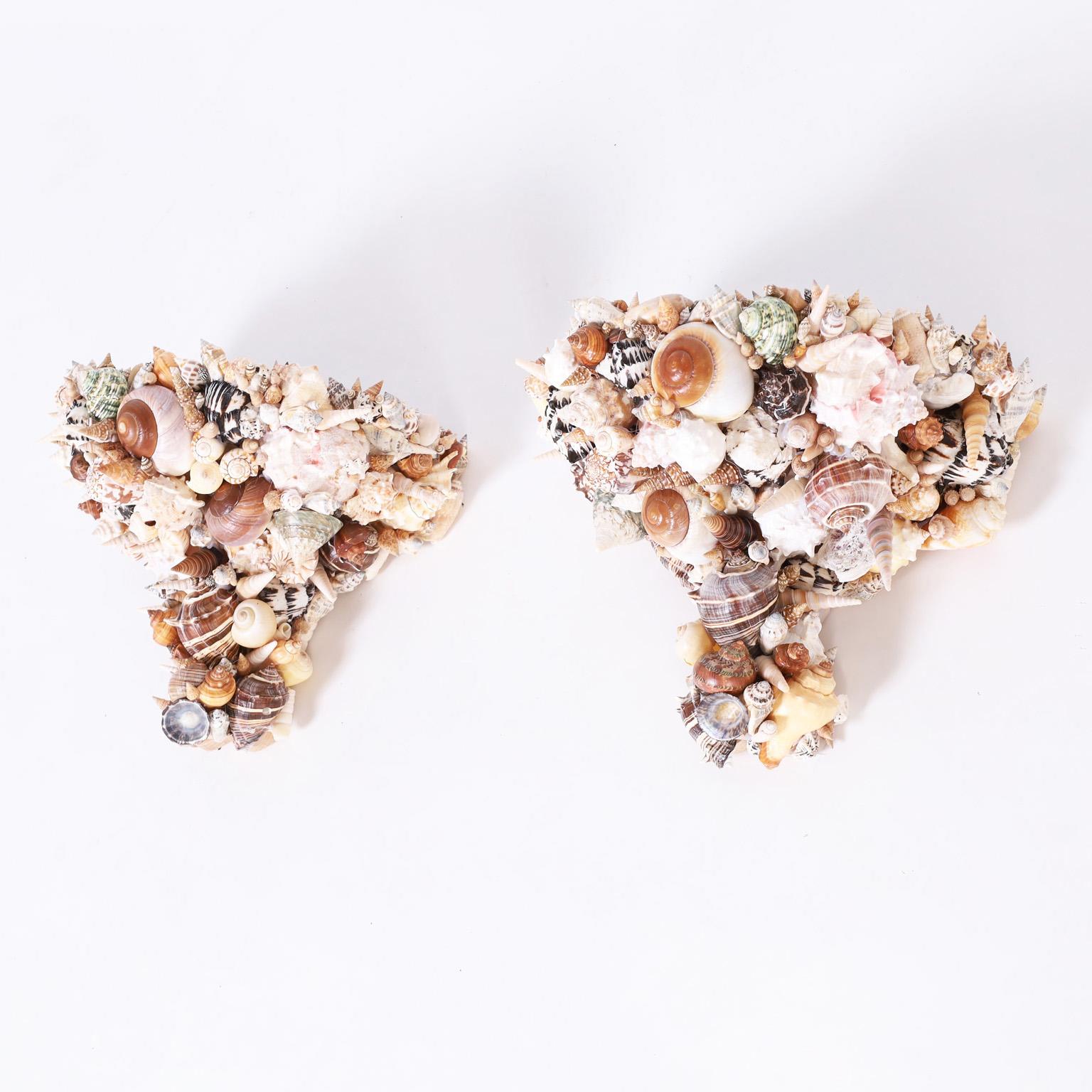 Pair of grotto like wall brackets crafted with a composition and wood frame entirely encrusted with an ambitious array of exotic seashells.
