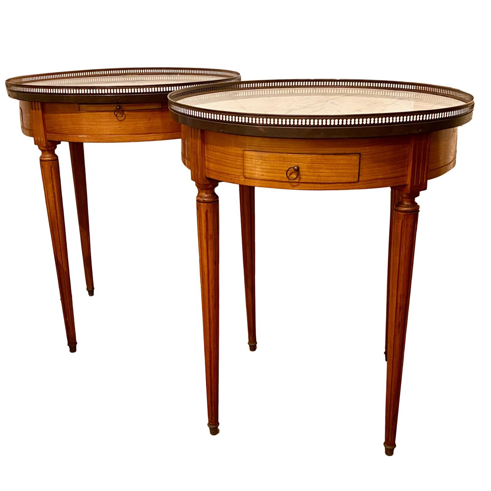 Paire de tables de guéridon en bois, datant des années 1930, avec un plateau en marbre et une rampe en laiton autour du plateau.

Mesures
Hauteur 29
