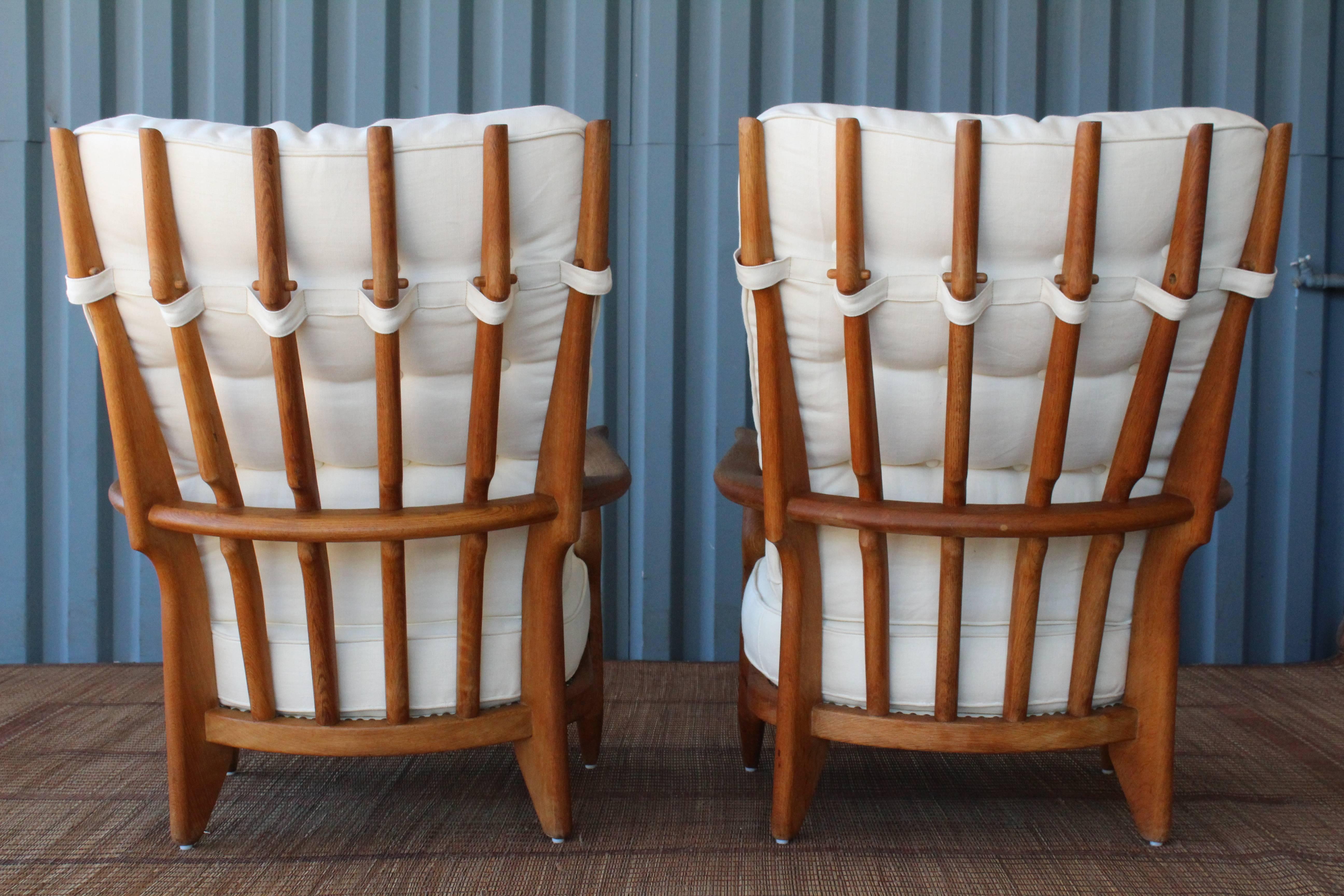 Stunning pair of 'Grand Repos' armchairs designed by Guillerme et Chambron for Votre Maison, France, 1960s. The pair are crafted in solid oak and feature new upholstery in an off white French hemp linen.