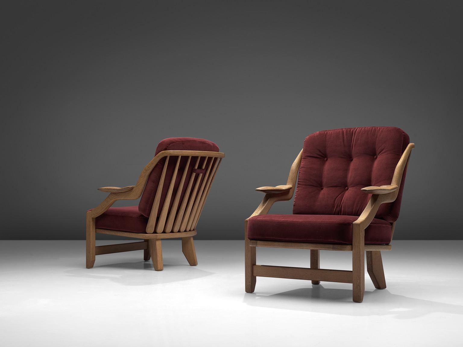 Guillerme et Chambron, pair of lounge chairs burgundy fabric and oak, France, 1950s.

This French designer duo is known for their extreme high quality solid oak furniture, from which this orange set is another great example. These chairs have a very
