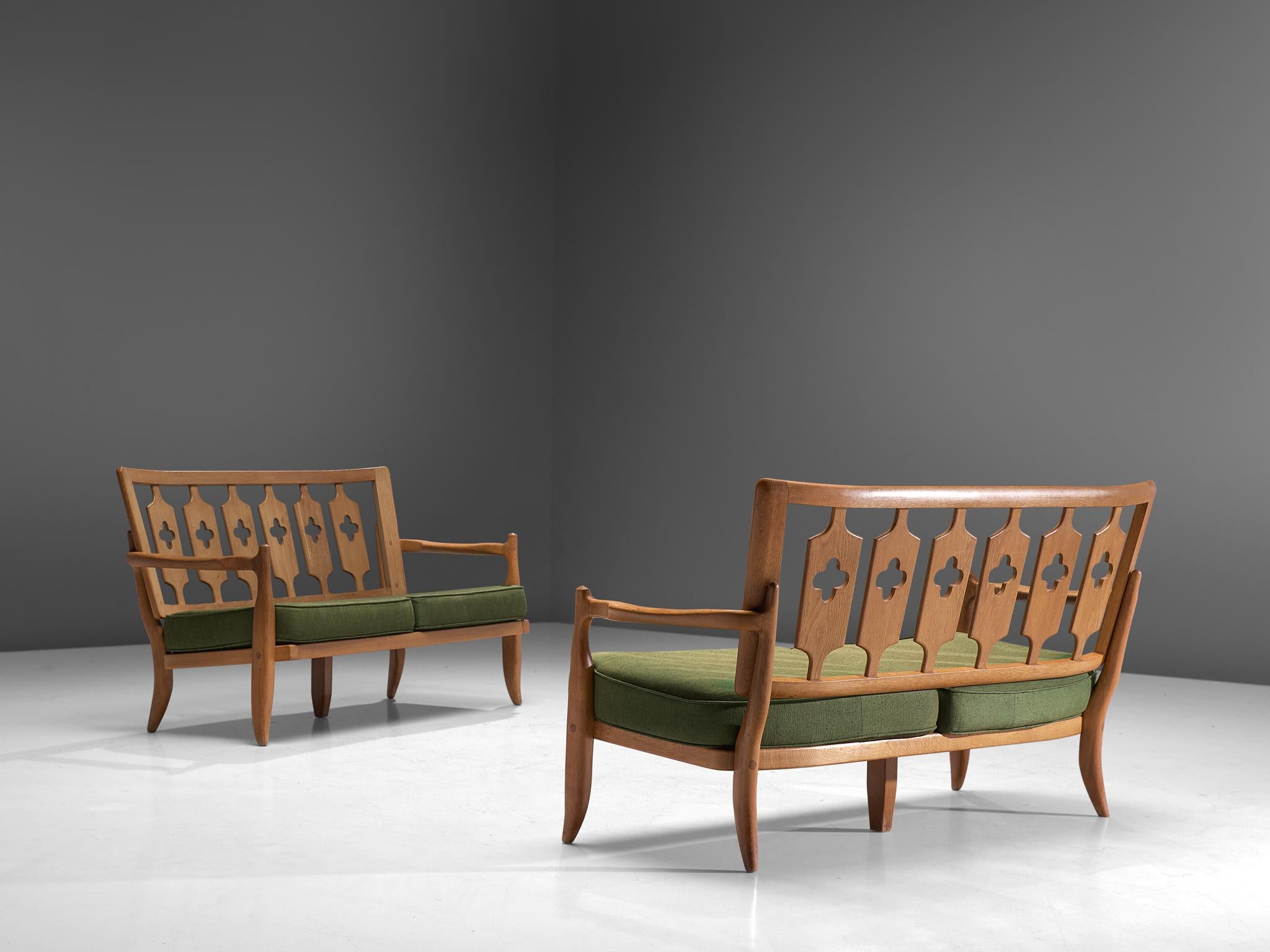 Guillerme et Chambron, pair of sofas, oak and fabric, France, 1960s.

Beautiful two-seat settees by Guillerme and Chambron, in solid oak with the typical characteristic decorative details at the back and sculpted forms of the legs. The thick, green