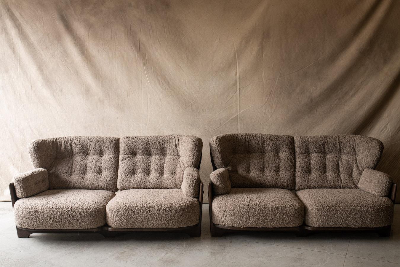 Vintage pair of Guillerme Et Chambron sofas, model Denis, from France, circa 1960. Solid stained oak construction. Cushions are later upholstered in a soft light grey, creme boucle fabric.

We don't have the time to write an extensive description on