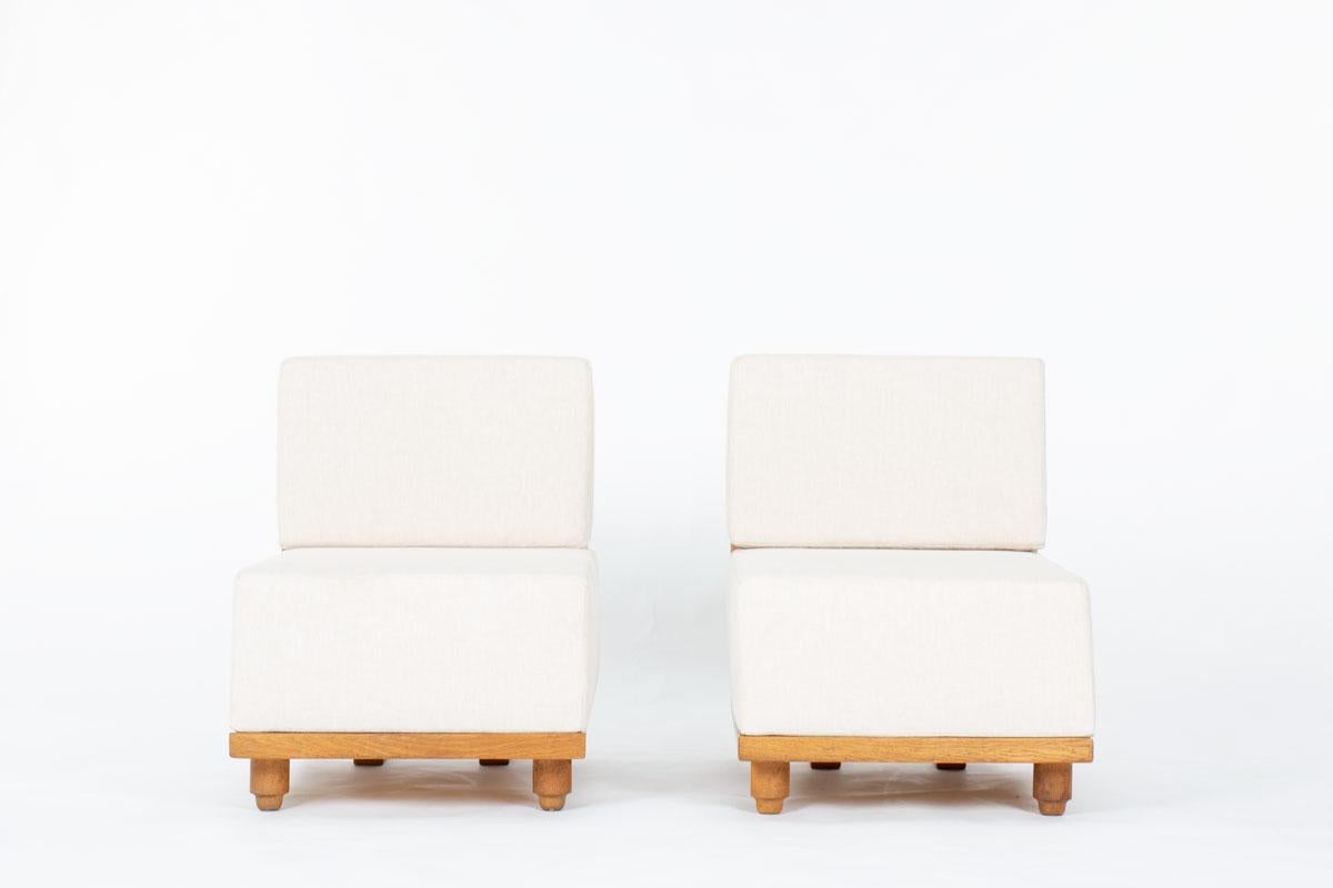 Cette paire exceptionnelle de fauteuils de Robert Guillerme et Jacques Chambron capture l'essence du design français des années 1950. Créées pour l'influent éditeur Votre Maison, elles présentent des montures audacieuses et sculpturales en chêne