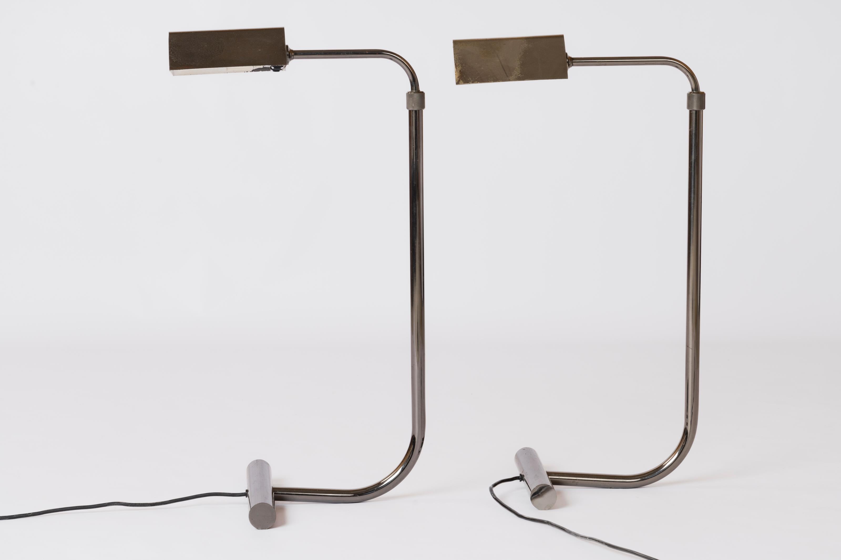Roger Nathan's iconic adjustable height reading lamps. In high quality make gunmetal plated brass. Both lamps also rotate 360° horizontally and the shade offer the same adjustment. Each lamp features two bulb sockets and two individual hand