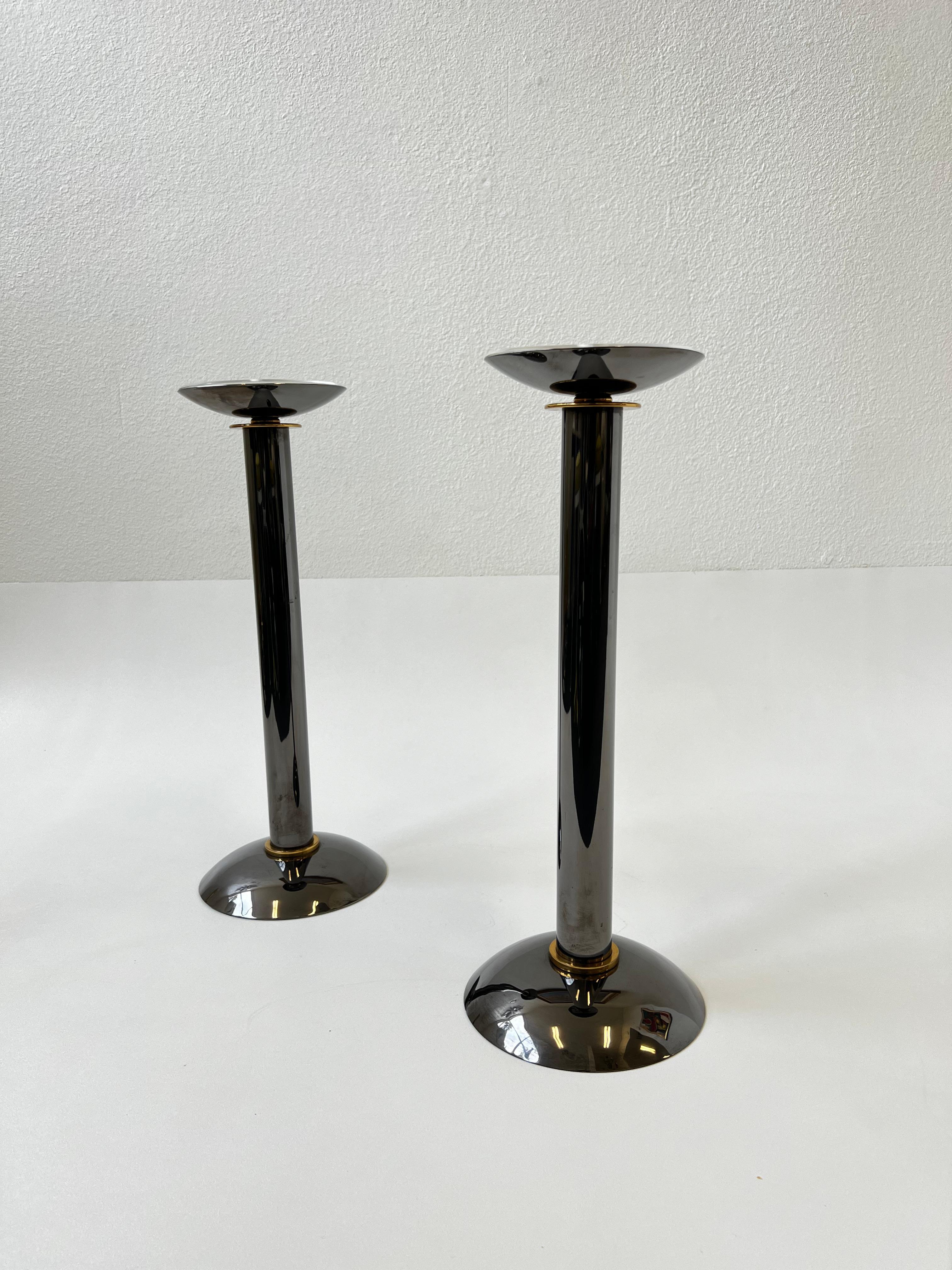 1980’s Large pair of polis gunmetal and brass with acrylic protectors candleholders by Karl Springer. 
In beautiful vintage condition. 
We also have a set another pair in a different listing, shown in last photo. 

Dim: 19.75” High, 7.5” Diameter.
